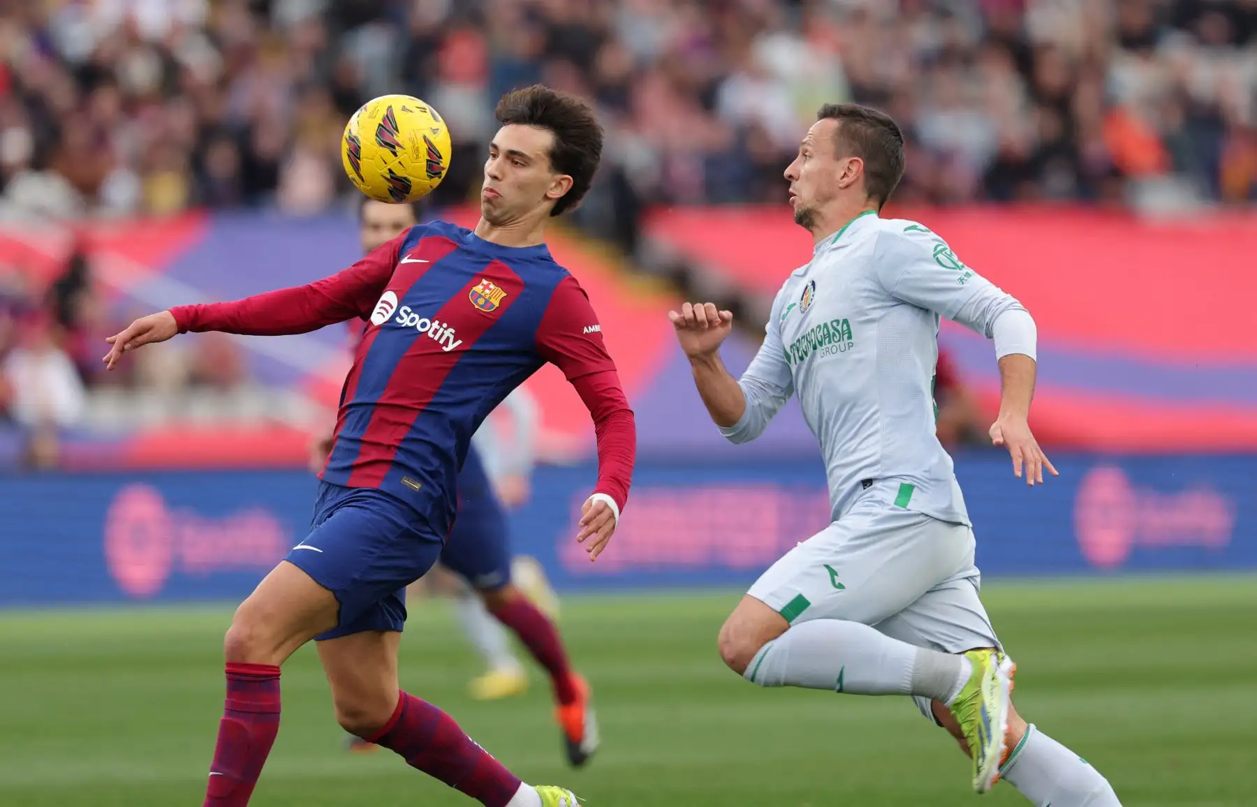 El delantero portugués del Barcelona Joao Felix compite con el centrocampista serbio del Getafe Nemanja Maksimovic durante el partido de fútbol de la liga española entre el FC Barcelona y el Getafe CF en el Estadi Olimpic Lluis Companys de Barcelona. Foto: ANDINA/AFP