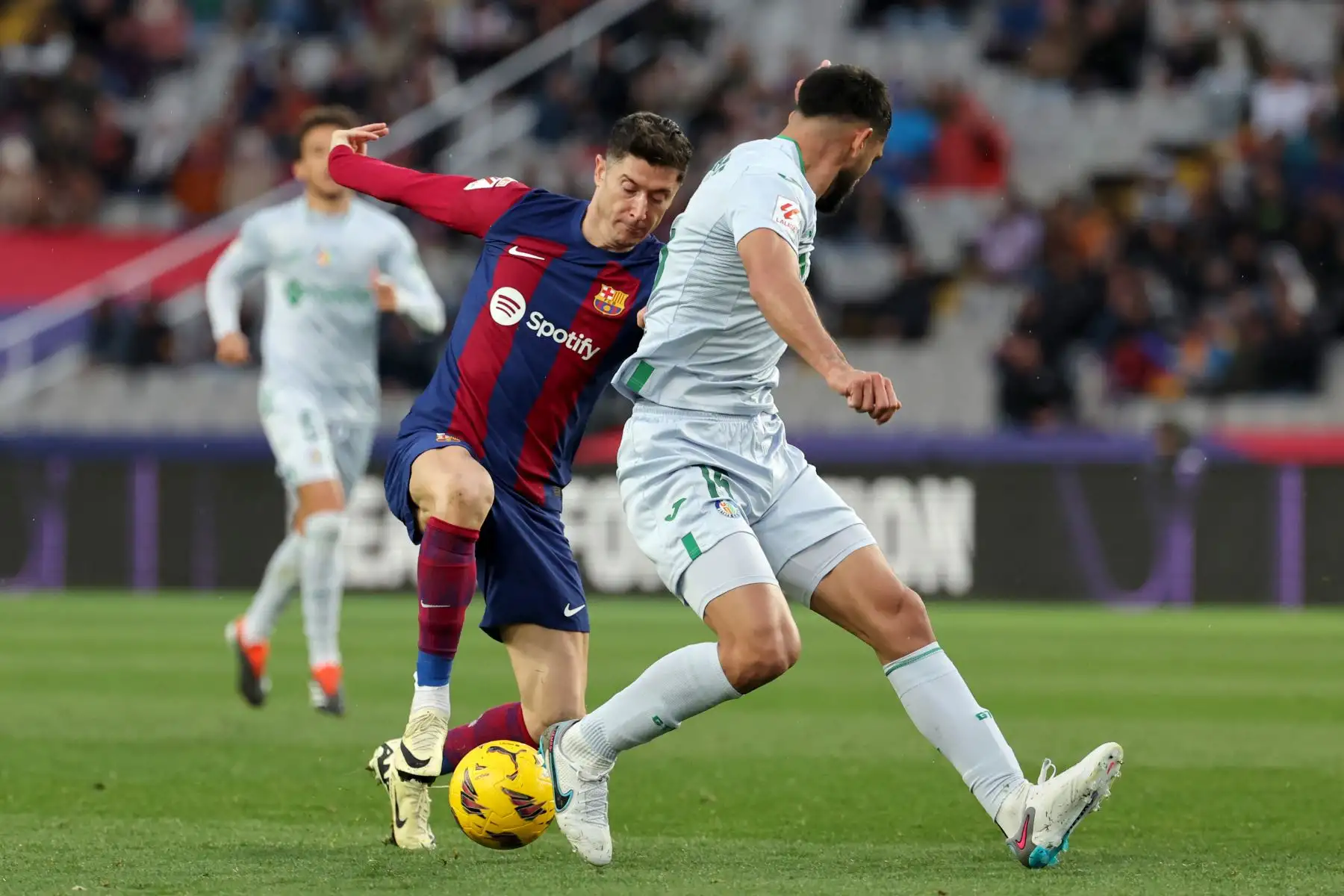 El delantero polaco del Barcelona Robert Lewandowski compite con el defensa paraguayo del Getafe  Omar Alderete durante el partido de fútbol de la liga española entre el FC Barcelona y el Getafe CF en el Estadi Olimpic Lluis Companys de Barcelona. Foto. ANDINA/AFP