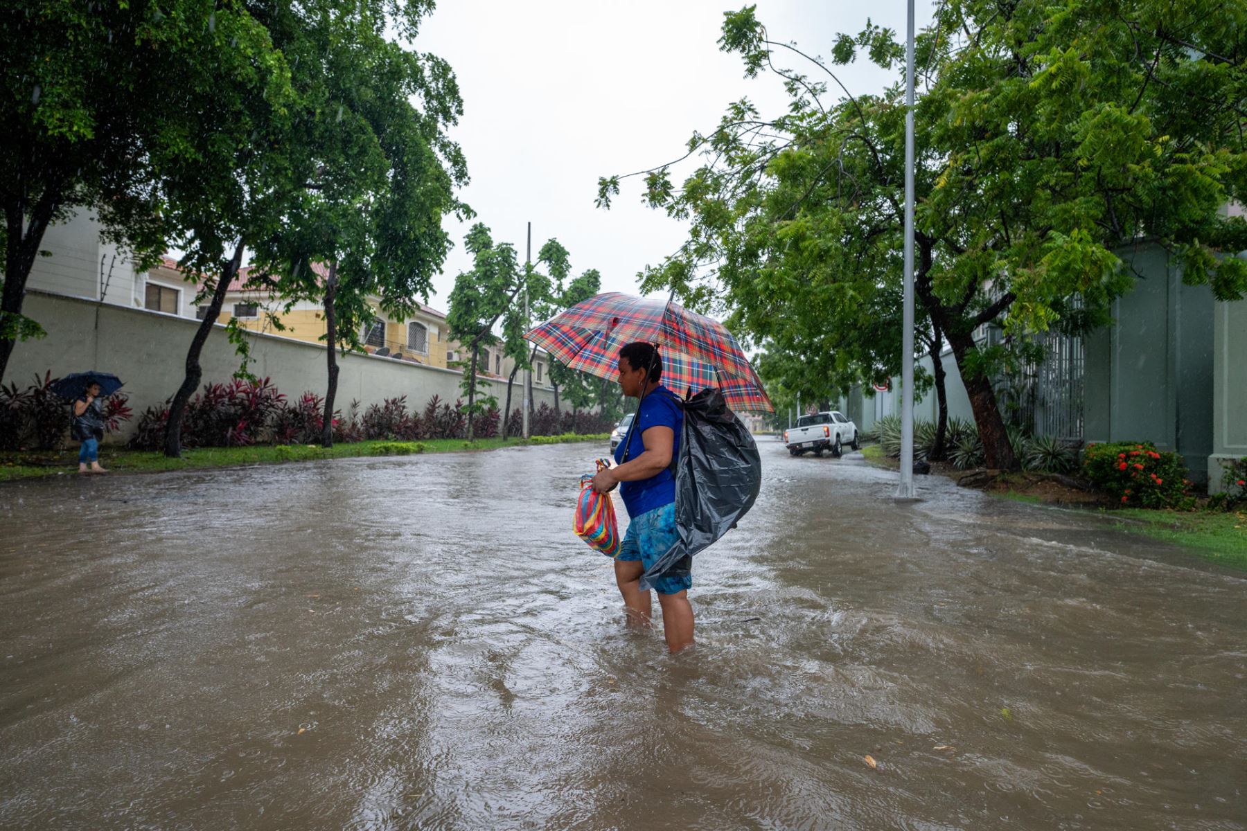 Una mujer camina por una calle inundada debido a las fuertes lluvias, este miércoles en Samborondon (Ecuador). 
Foto: EFE