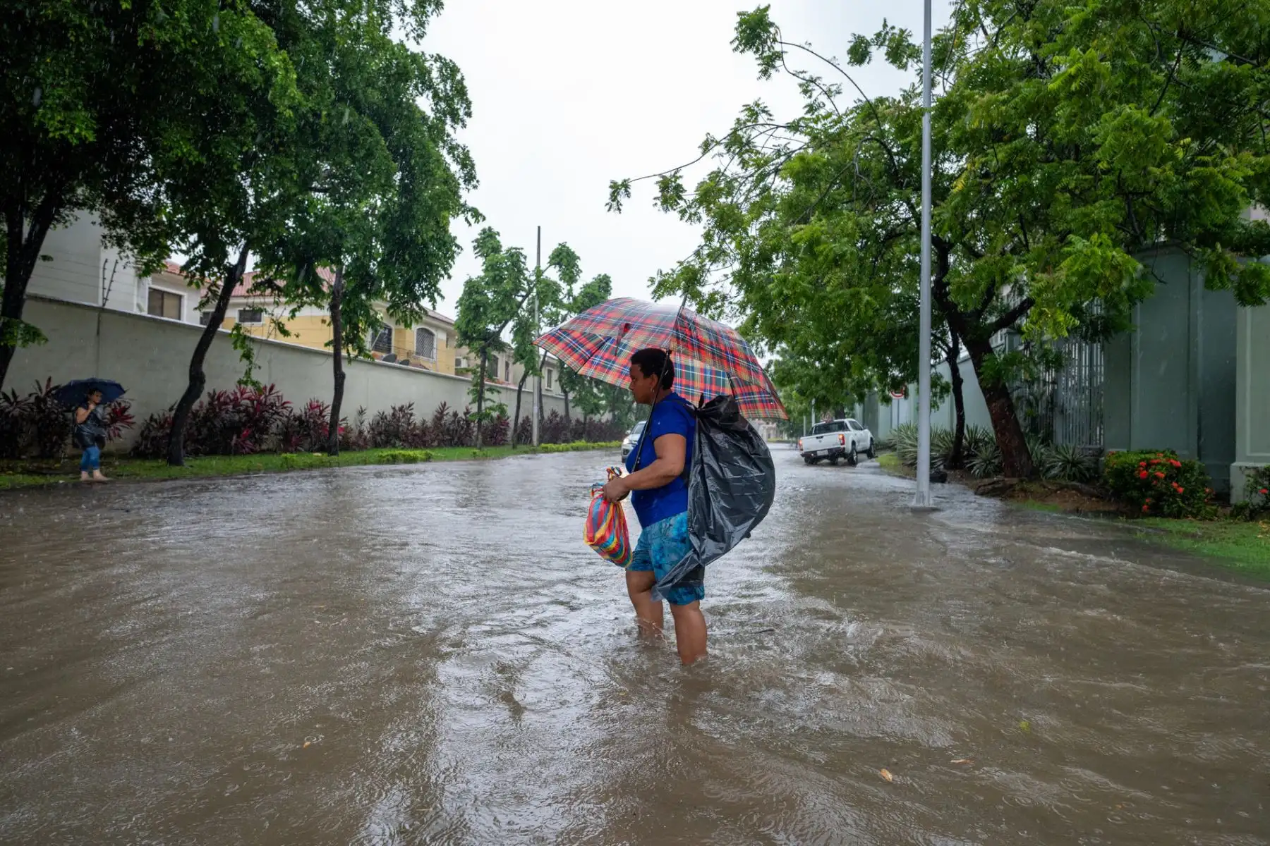 Una mujer camina por una calle inundada debido a las fuertes lluvias, este miércoles en Samborondon (Ecuador). 
Foto: EFE
