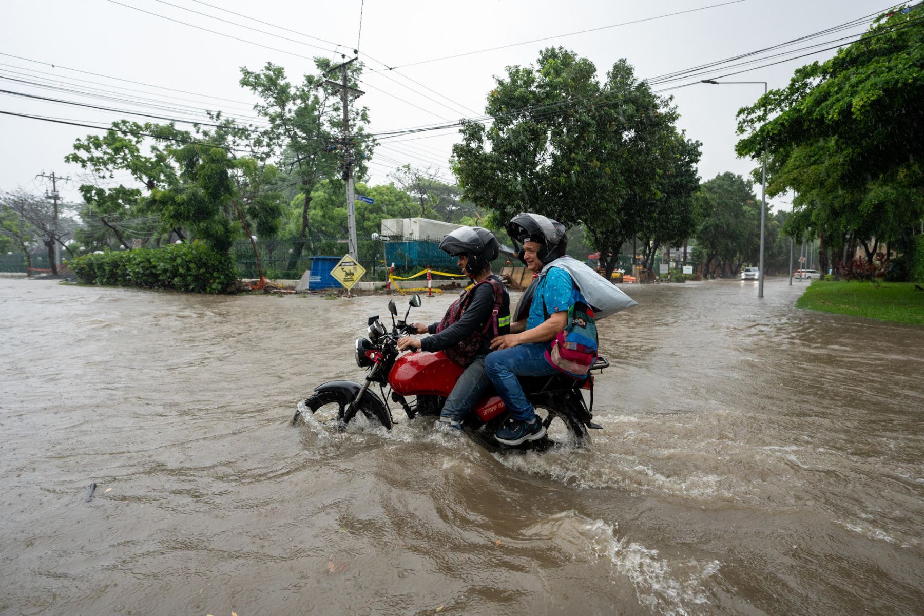 Motociclistas transitan por una calle inundada debido a las fuertes lluvias, este miércoles en Samborondon (Ecuador). 
Foto: EFE
