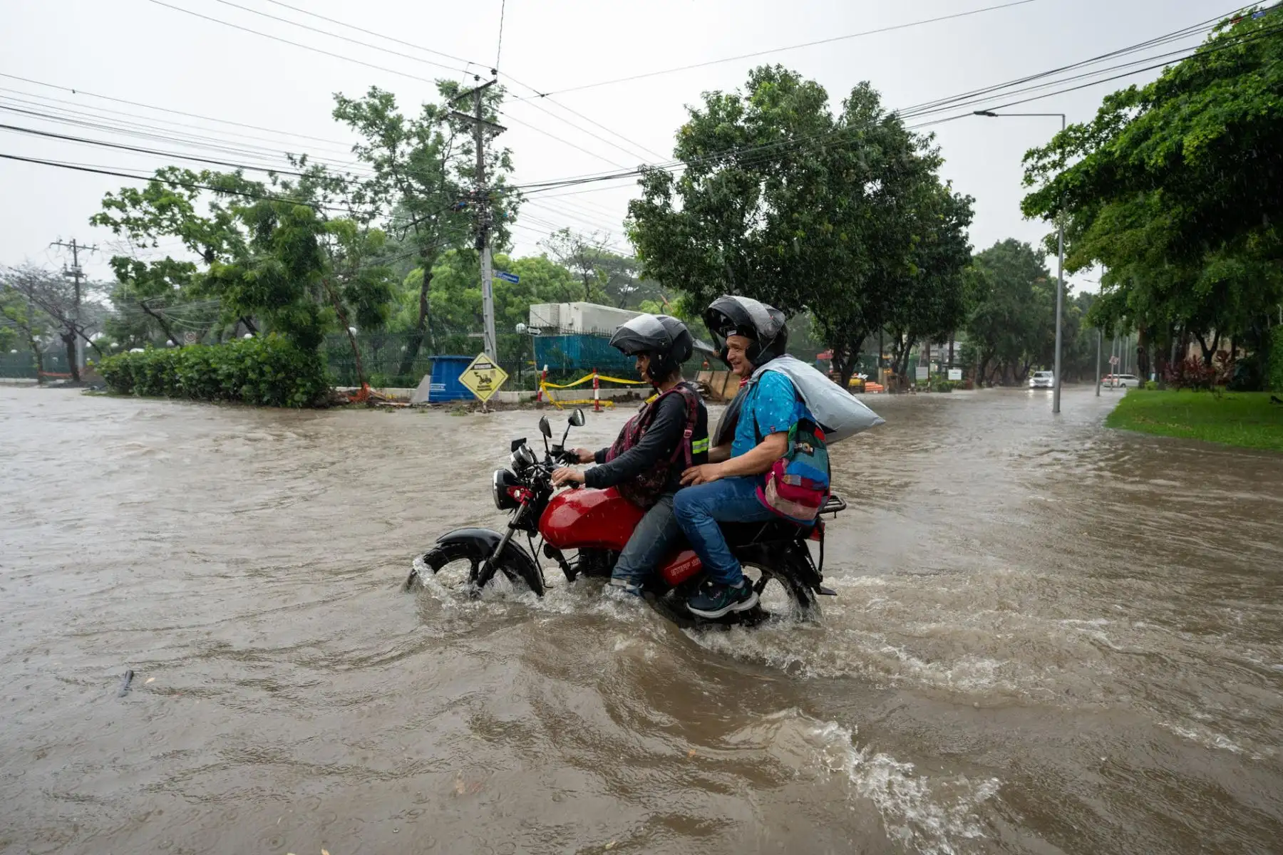 Motociclistas transitan por una calle inundada debido a las fuertes lluvias, este miércoles en Samborondon (Ecuador). 
Foto: EFE