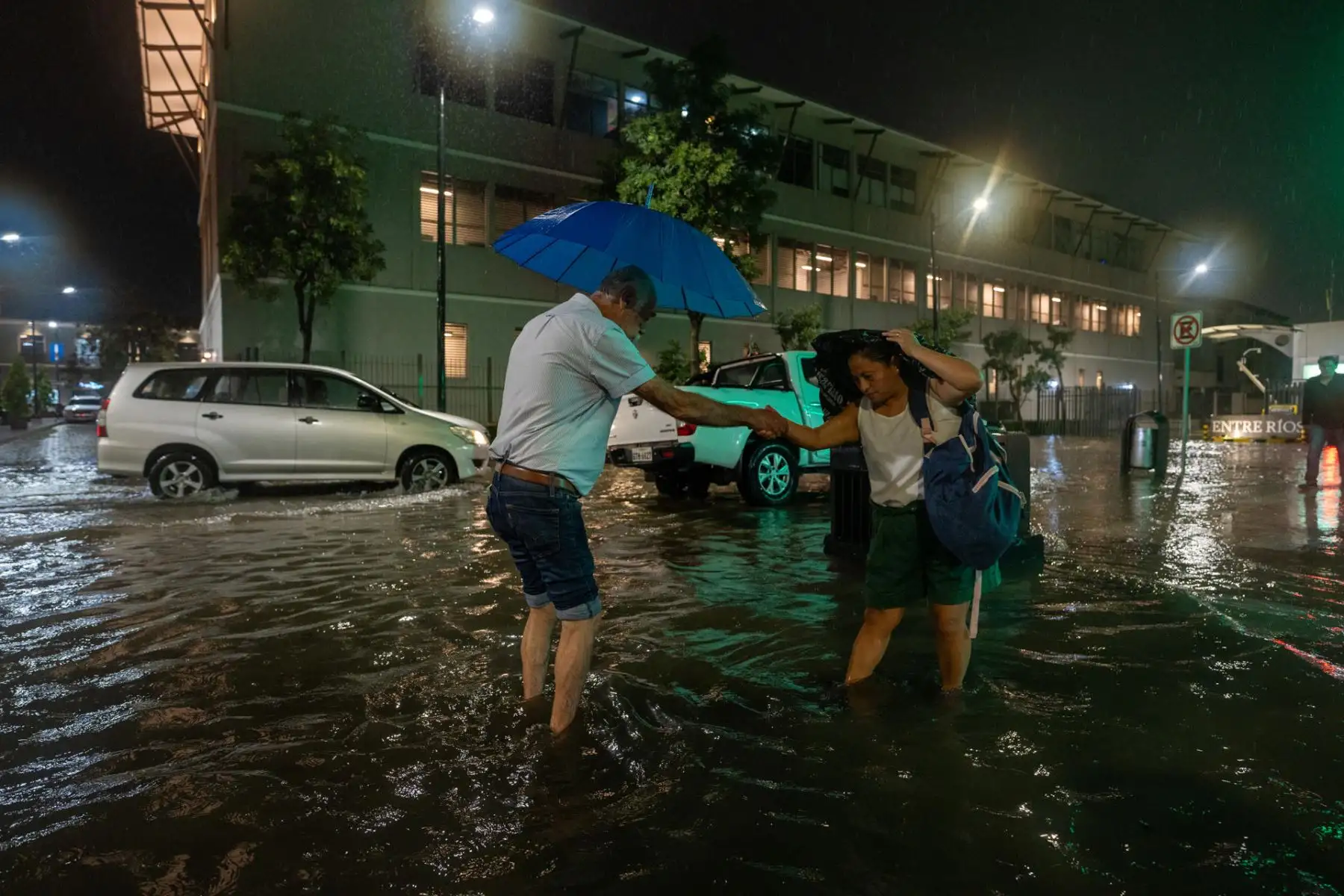 Unas personas caminan por una calle inundada debido a las fuertes lluvias, este miércoles en Samborondón (Ecuador). 
Foto: EFE