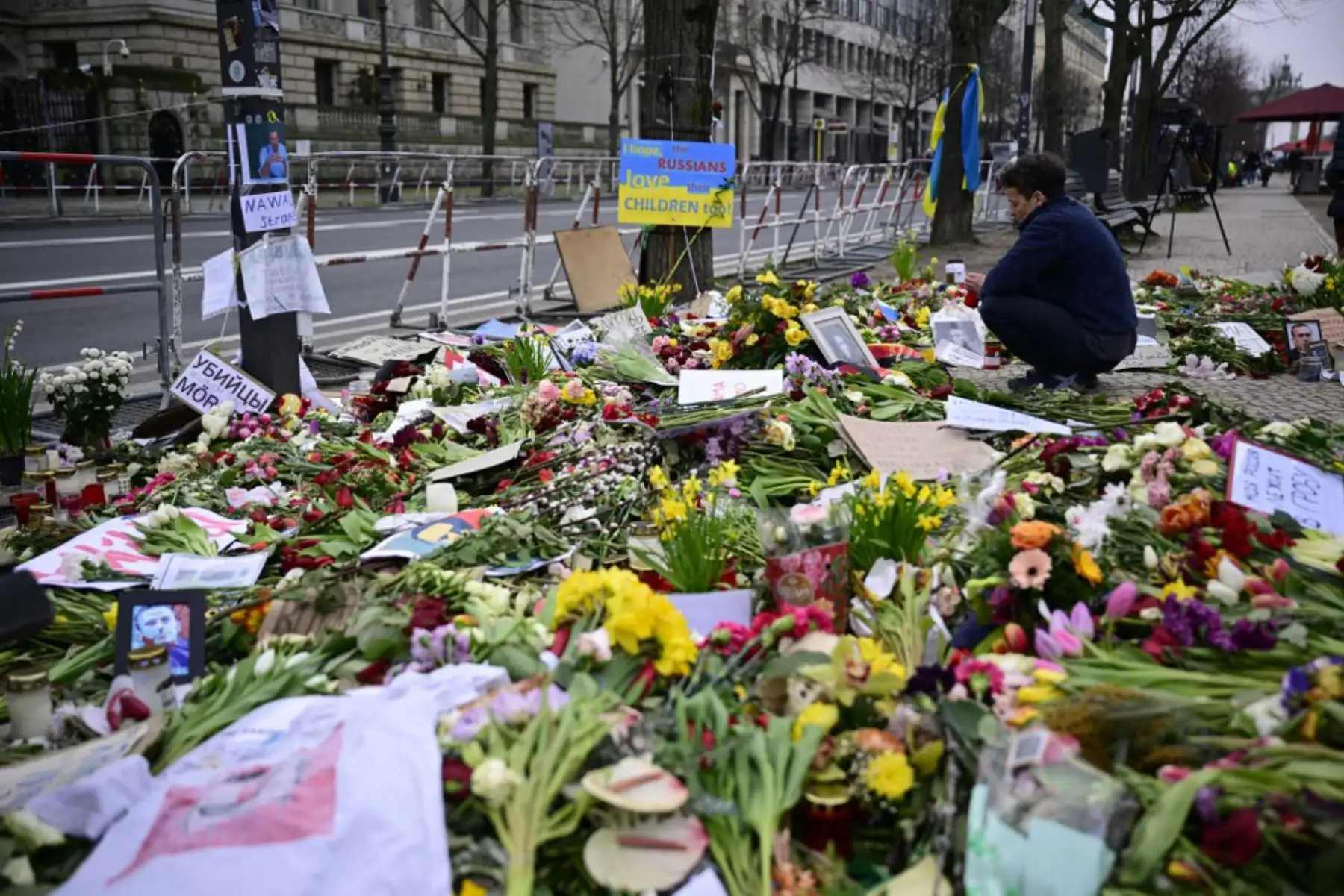 Una mujer enciende una vela en un improvisado monumento con flores y velas para el líder de la oposición rusa Alexei Navalny frente a la embajada rusa en Berlín. Foto: AFP