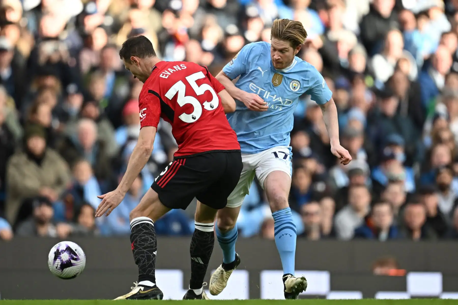 El centrocampista belga del Manchester City Kevin De Bruyne compite con el defensor norirlandés del Manchester United  Jonny Evans durante el partido de fútbol de la Liga Premier inglesa entre Manchester City y Manchester United en el Etihad Stadium de Manchester, noroeste de Inglaterra.Foto: ANDINA/ AFP