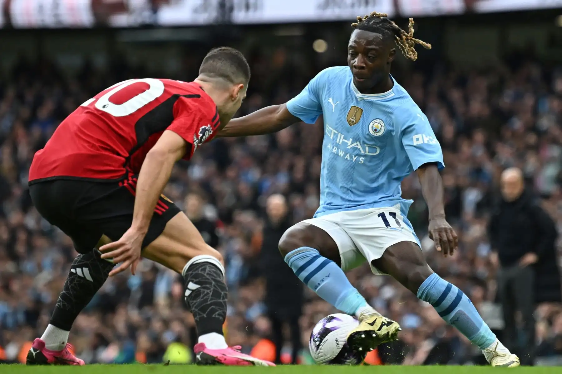 El centrocampista belga del Manchester City Jeremy Doku  compite con el defensor portugués del Manchester United Diogo Dalot  durante el partido de fútbol de la Premier League inglesa entre Manchester City y Manchester United en el estadio Etihad de Manchester, noroeste de Inglaterra.
 Foto: ANDINA/ AFP