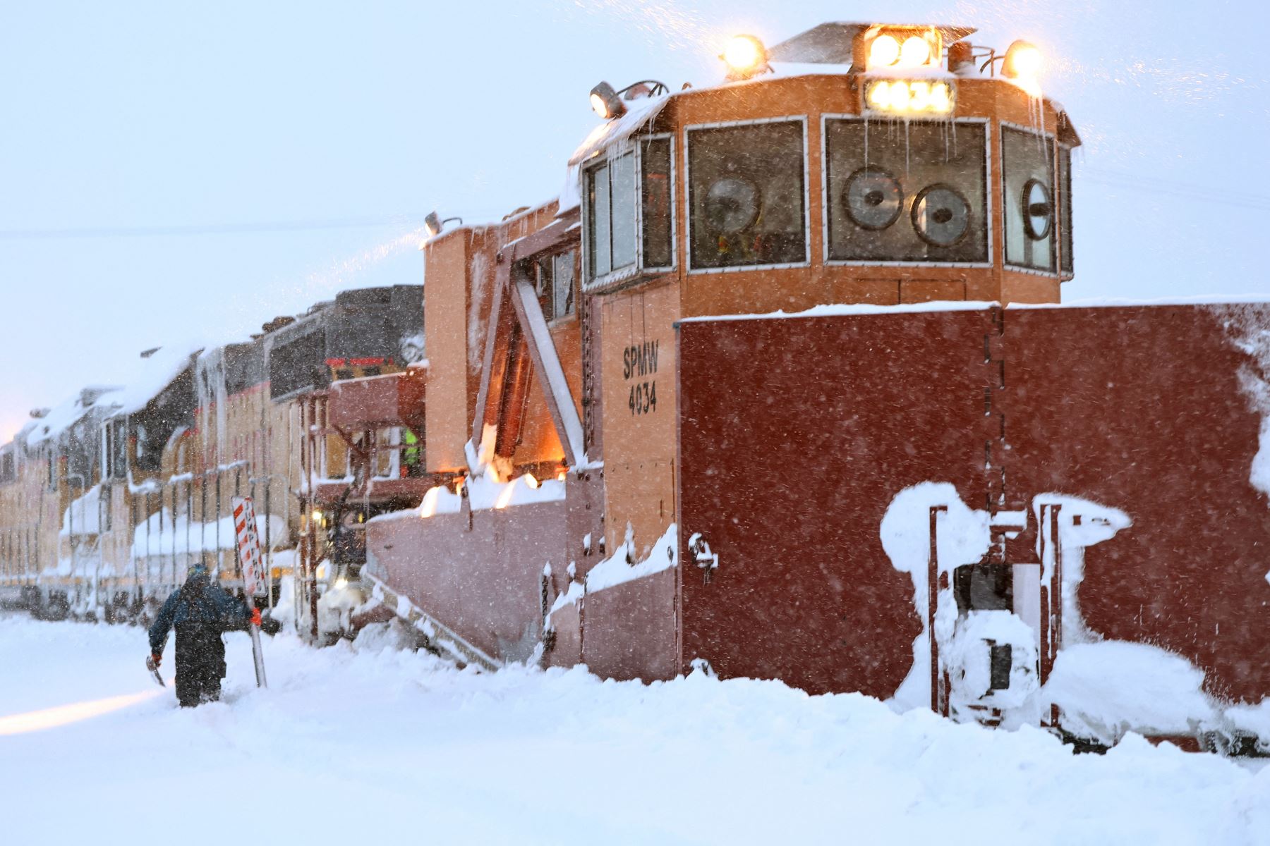 Un trabajador de Union Pacific camina para abordar un tren de mantenimiento limpiando las pistas de nieve con un quitanieves, conocido como 