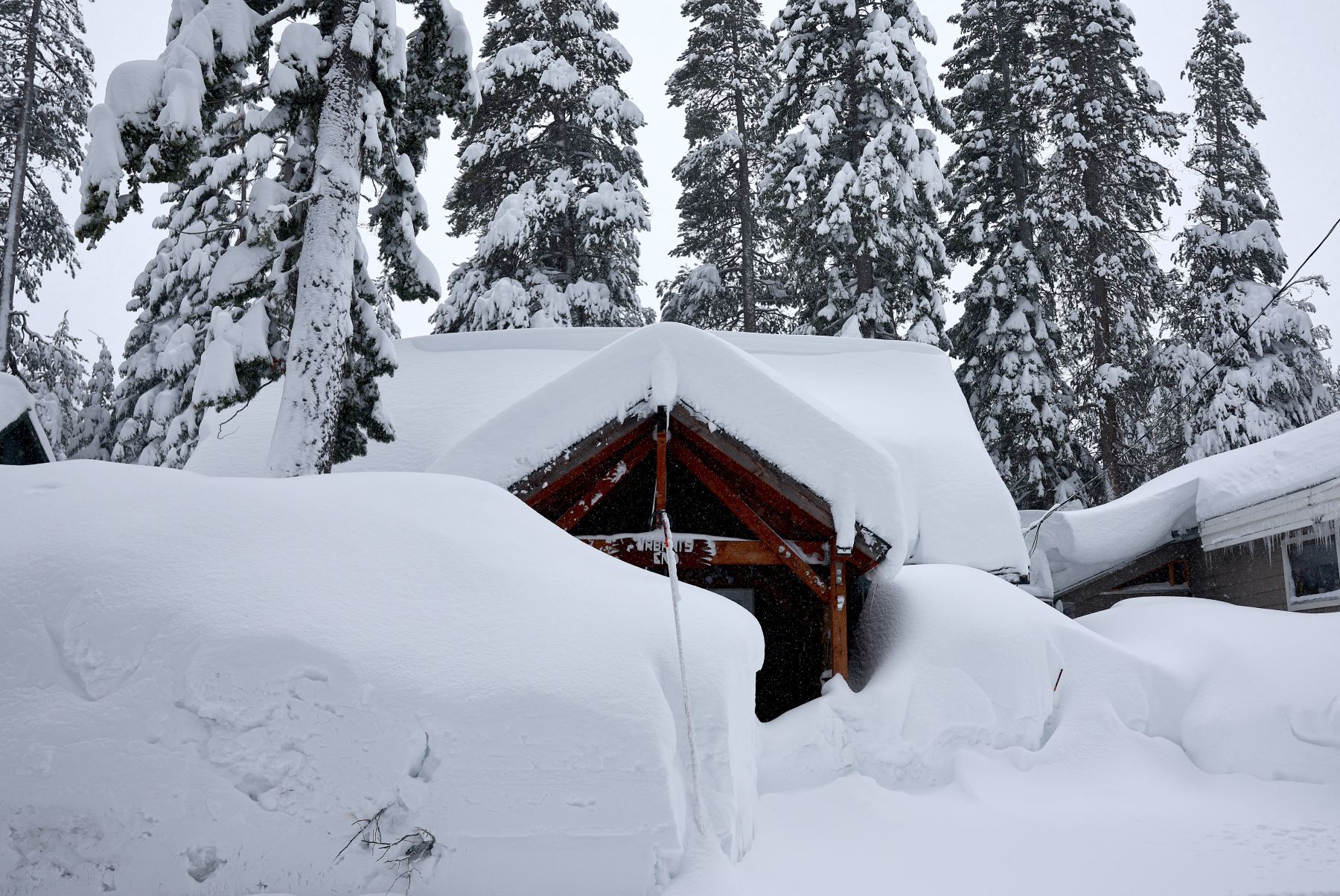 Las casas están cubiertas de nieve durante una poderosa tormenta invernal de varios días en las montañas de Sierra Nevada, que está aumentando la capa de nieve,  en Truckee, California. 
Foto: AFP