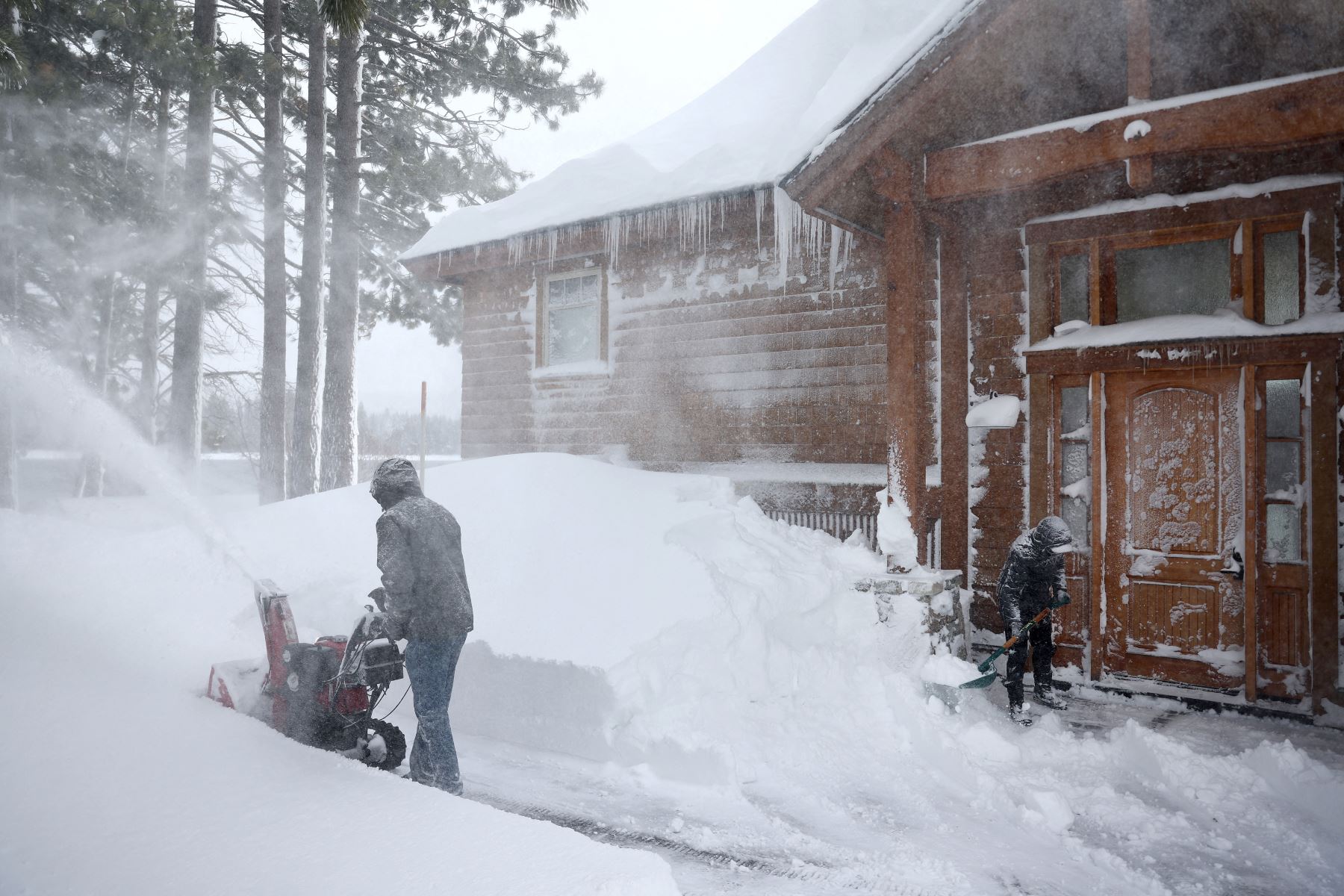 Los residentes limpian la nieve frente a su casa durante una poderosa tormenta invernal de varios días en las montañas de Sierra Nevada, que está aumentando la capa de nieve, el 3 de marzo de 2024 en Truckee, California.