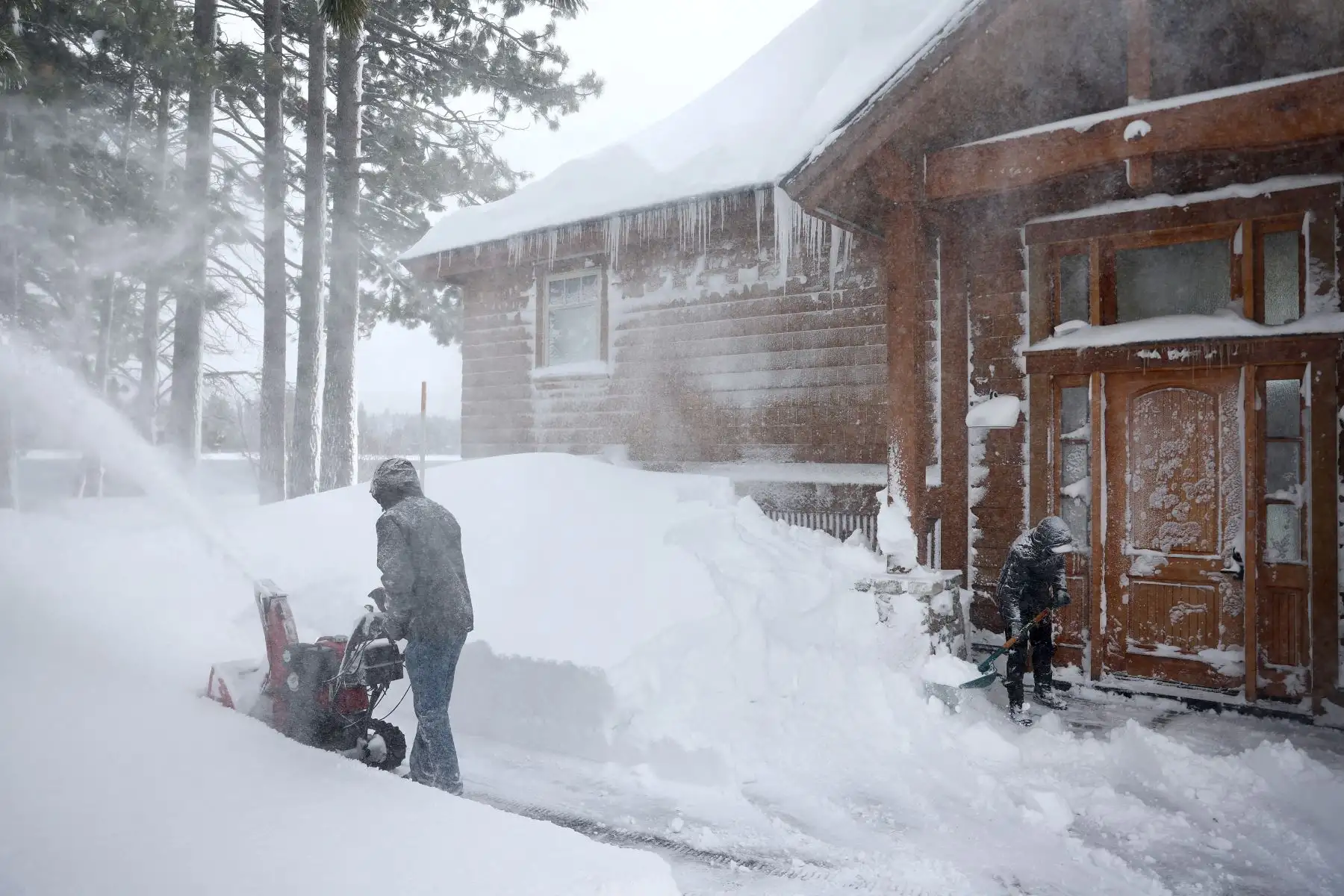 Los residentes limpian la nieve frente a su casa durante una poderosa tormenta invernal de varios días en las montañas de Sierra Nevada, que está aumentando la capa de nieve, el 3 de marzo de 2024 en Truckee, California.
