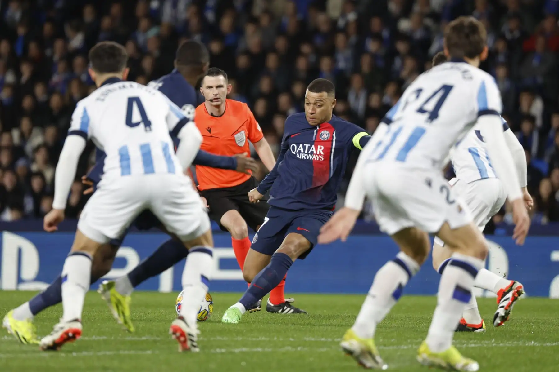 El delantero del PSG, Kylian Mbappe, realiza una jugada de ataque ante los defensores de la Real Sociedad durante el encuentro correspondiente a la vuelta de los octavos de final de la Liga de Campeones en el Reale Arena, en San Sebastián. Foto: EFE