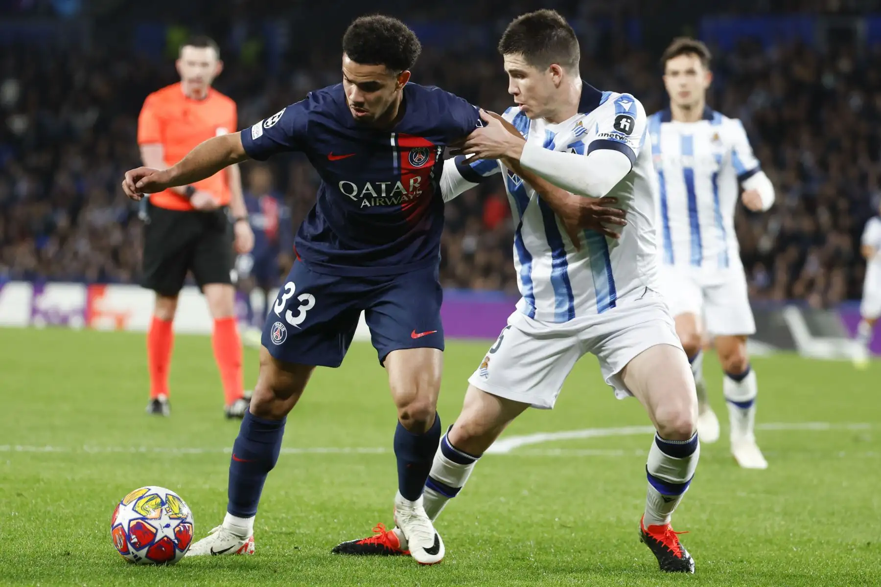 El defensa de la Real Sociedad, Igor Zubeldia, disputa un balón ante el centrocampista francés del PSG Warren Zaïre-Emery, durante el encuentro de vuelta de octavos de final de Liga de Campeones entre ambos equipos en el estadio Reale Arena en San Sebastián. Foto: EFE