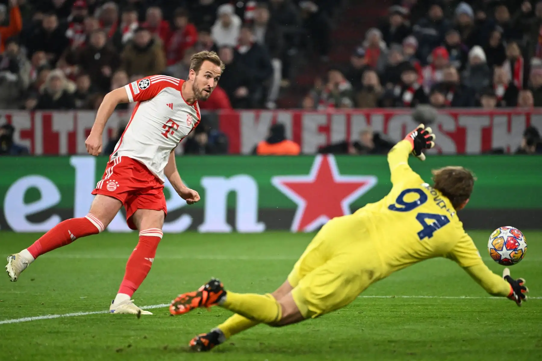 El delantero inglés del Bayern Múnich, Harry Kane, anota el 3-0 ante el portero italiano del Lazio, Ivan Provedel, durante el partido de fútbol de vuelta de los octavos de final de la Liga de Campeones de la UEFA en Múnich, Alemania. Foto: AFP