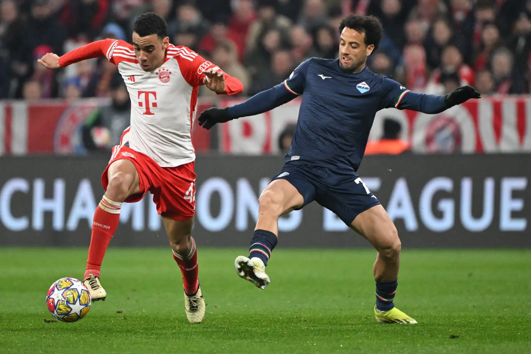 El centrocampista alemán del Bayern Múnich, Jamal Musiala, y el centrocampista brasileño del Lazio, Felipe Anderson, compiten por el balón durante el partido de vuelta de octavos de final de la Liga de Campeones de la UEFA en Múnich, Alemania. Foto: AFP