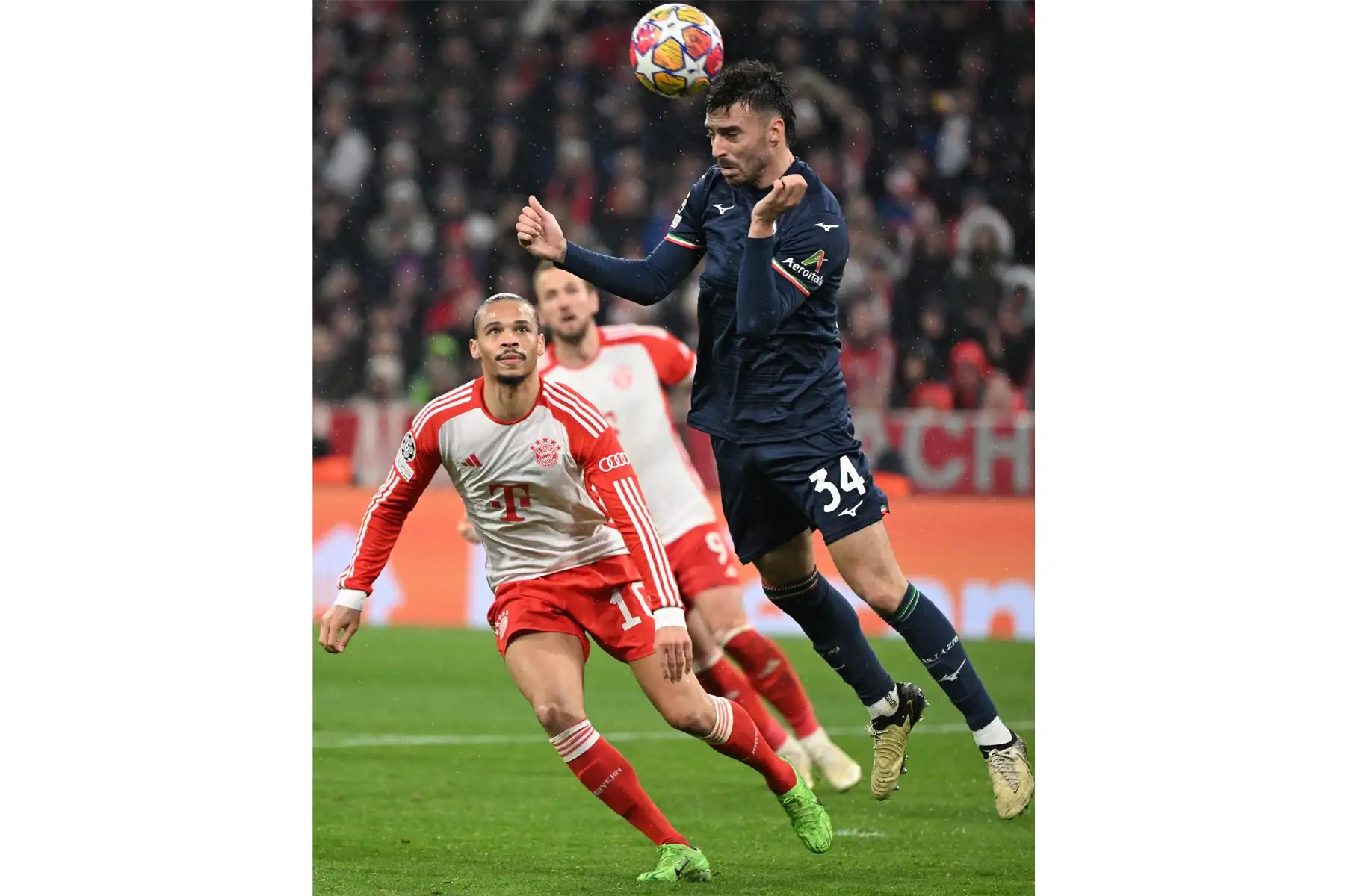 El defensor español del Lazio, Mario Gila Fuentes, y el delantero alemán del Bayern Múnich, Leroy Sane, compiten por el balón durante el partido de vuelta de los octavos de final de la Liga de Campeones de la UEFA en Múnich, Alemania. Foto: AFP