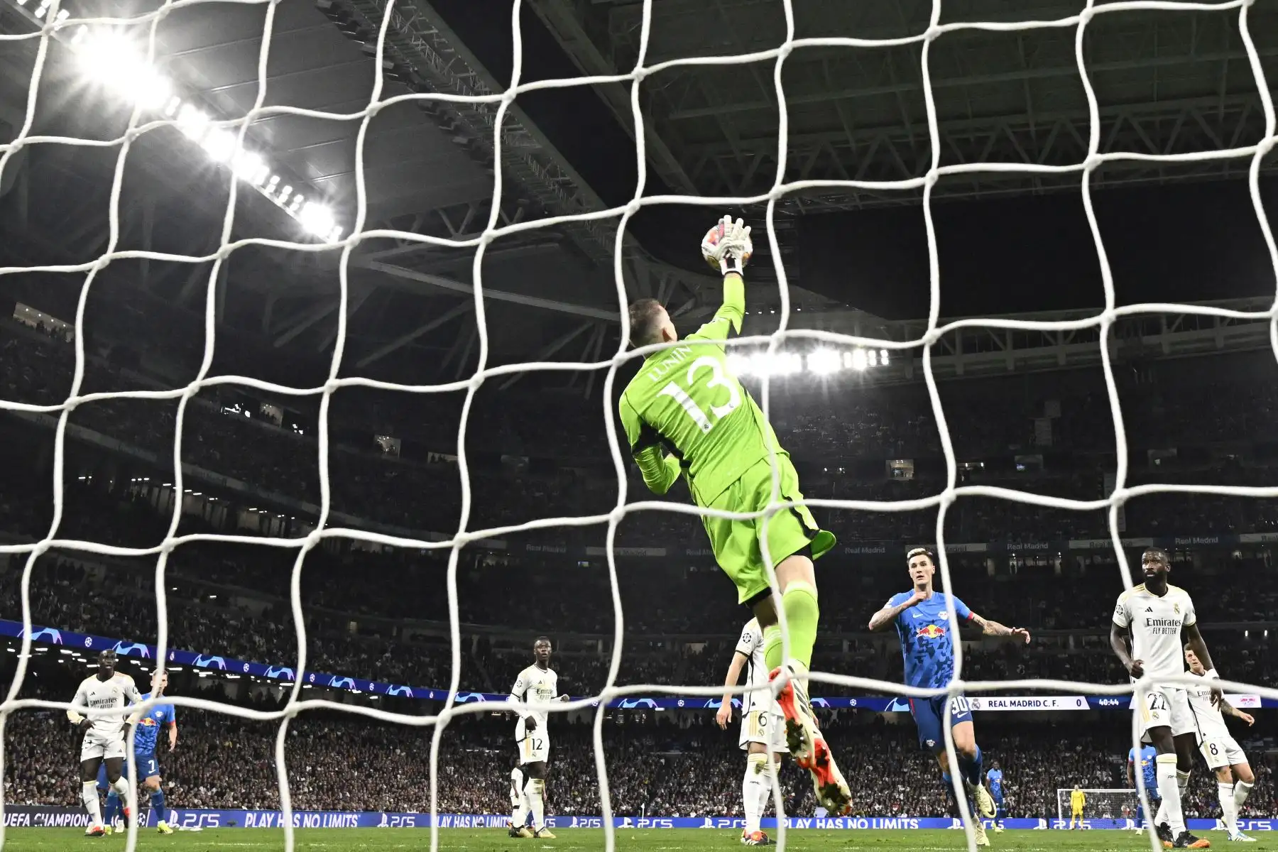 El portero ucraniano  del Real Madrid, Andriy Lunin, hace una parada durante el partido de vuelta de octavos de final de la Liga de Campeones de la UEFA entre el Real Madrid CF y el RB Leipzig en el estadio Santiago Bernabeu de Madrid.
Foto: AFP