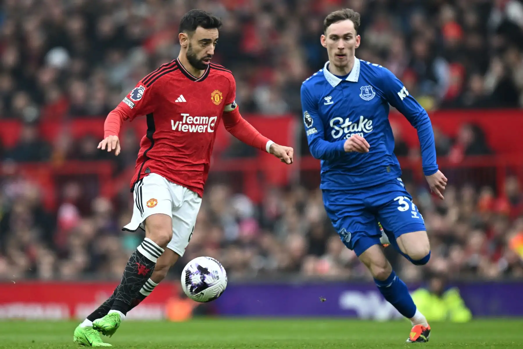 El centrocampista portugués del Manchester United Bruno Fernandes compite con el centrocampista inglés del Everton James Garner durante el partido de fútbol de la Premier League inglesa entre Manchester y Everton. Foto: ANDINA/AFP