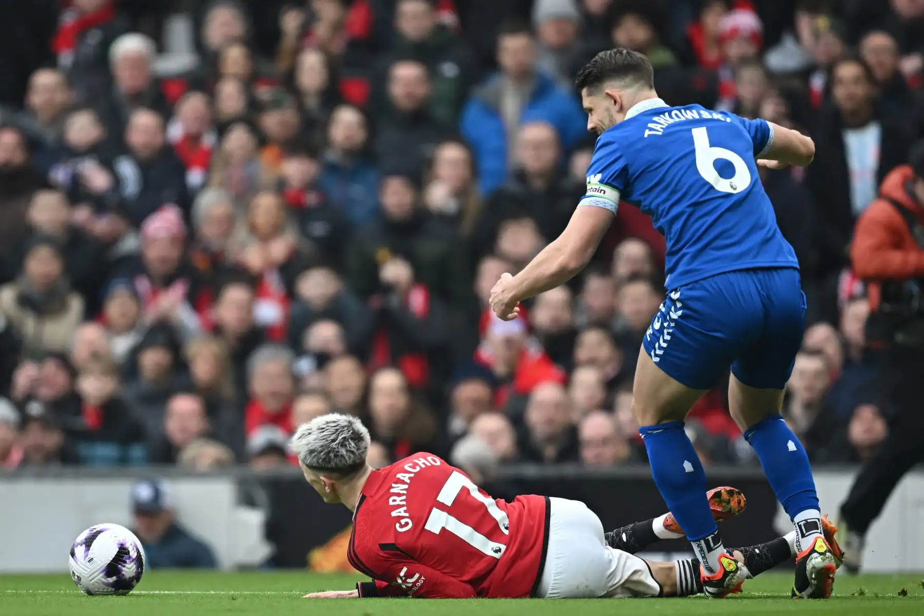 El defensor inglés del Everton James Tarkowski comete falta contra el centrocampista argentino del Manchester United Alejandro Garnacho durante el partido de fútbol de la Premier League inglesa entre Manchester United y Everton. Foto: ANDINA/ AFP