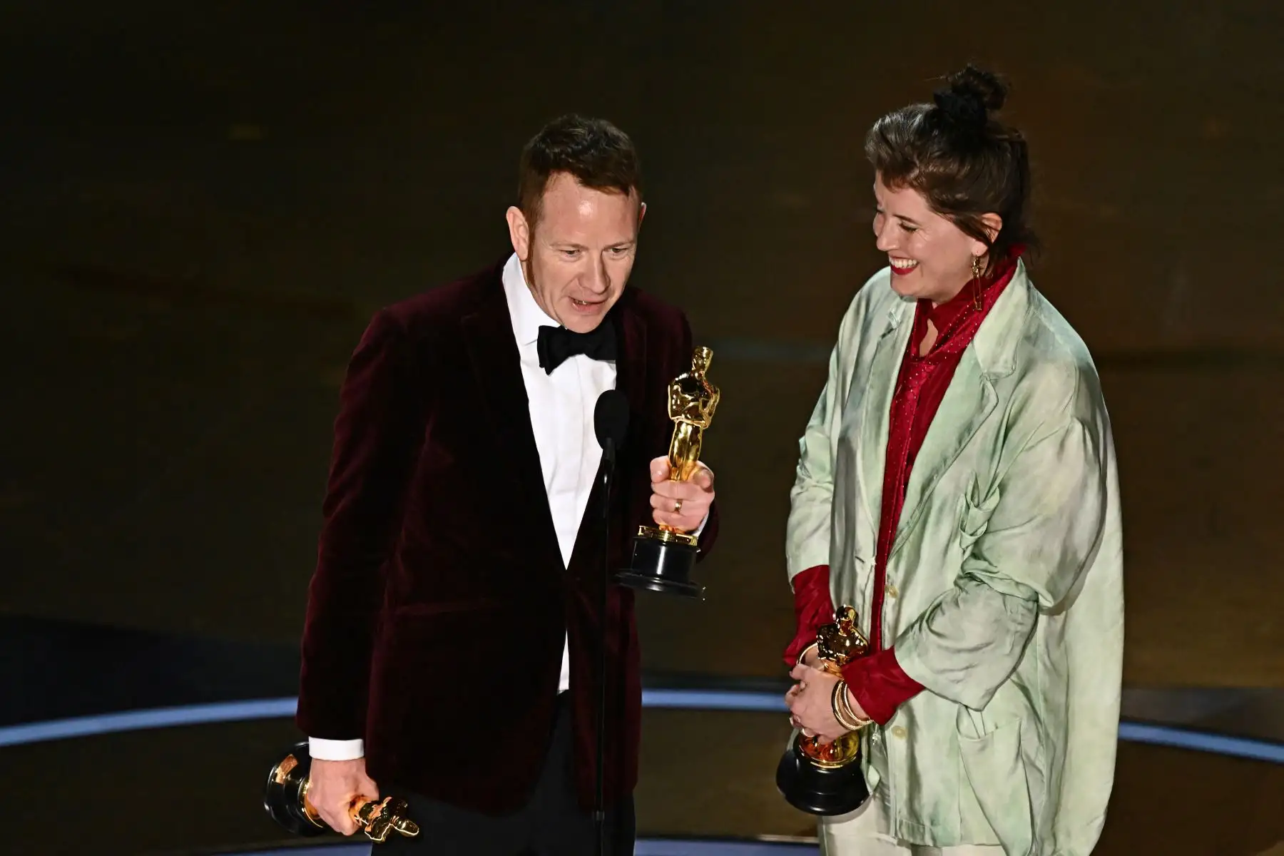 Los diseñadores de producción británicos James Price (izq.) y Shona Heath aceptan el premio al Mejor Diseño de Producción en el escenario por "Poor Things" durante la 96ª edición anual de los Premios de la Academia en el Dolby Theatre de Hollywood, California.