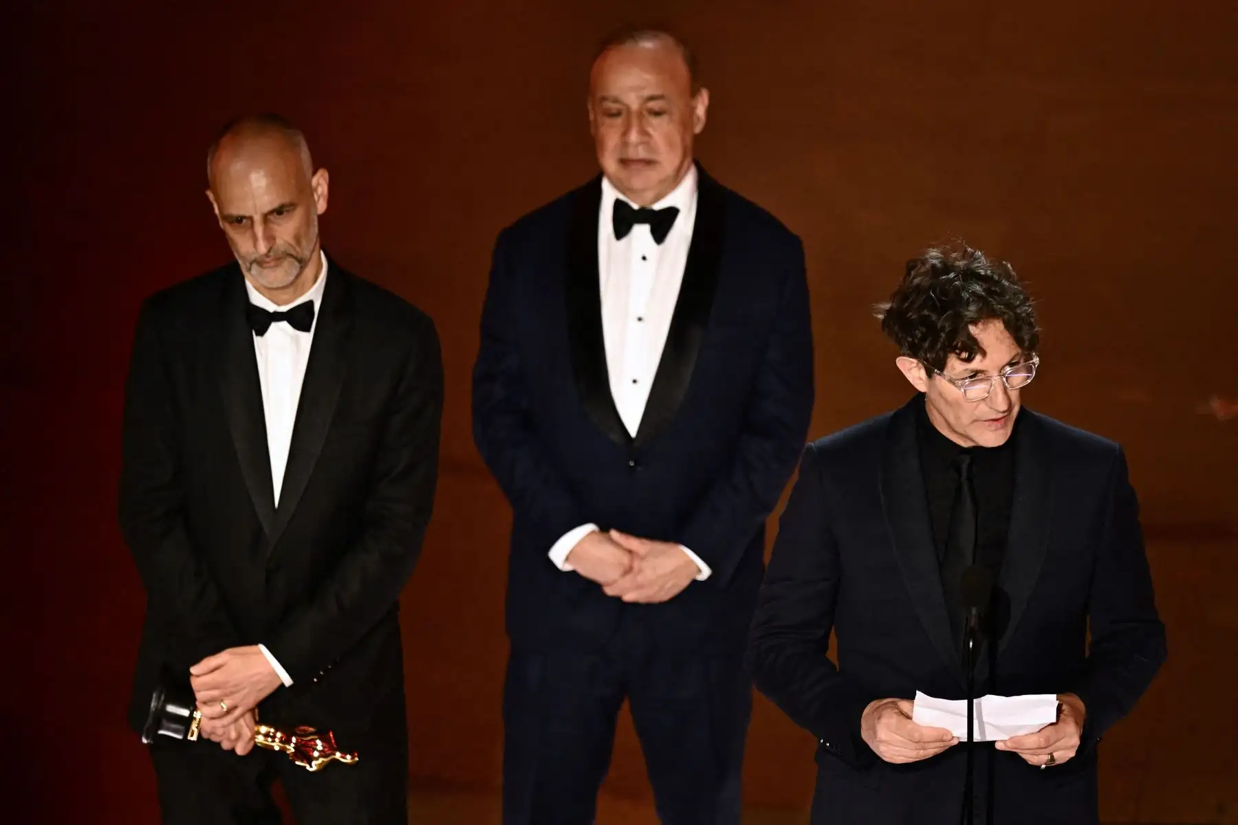 El director inglés Jonathan Glazer (derecha) acepta el premio a la Mejor Película Internacional por "The Zone of Interest", flanqueado por James Wilson (i), en el escenario durante la 96ª edición anual de los Premios de la Academia en el Dolby Theatre de Hollywood.