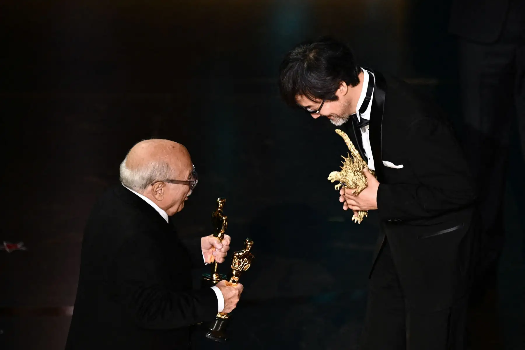 Takashi Yamazaki acepta el premio a los mejores efectos visuales por "Godzilla Minus One" del actor estadounidense Danny DeVito (i) en el escenario durante la 96ª edición anual de los Premios de la Academia en el Dolby Theatre de Hollywood, California.