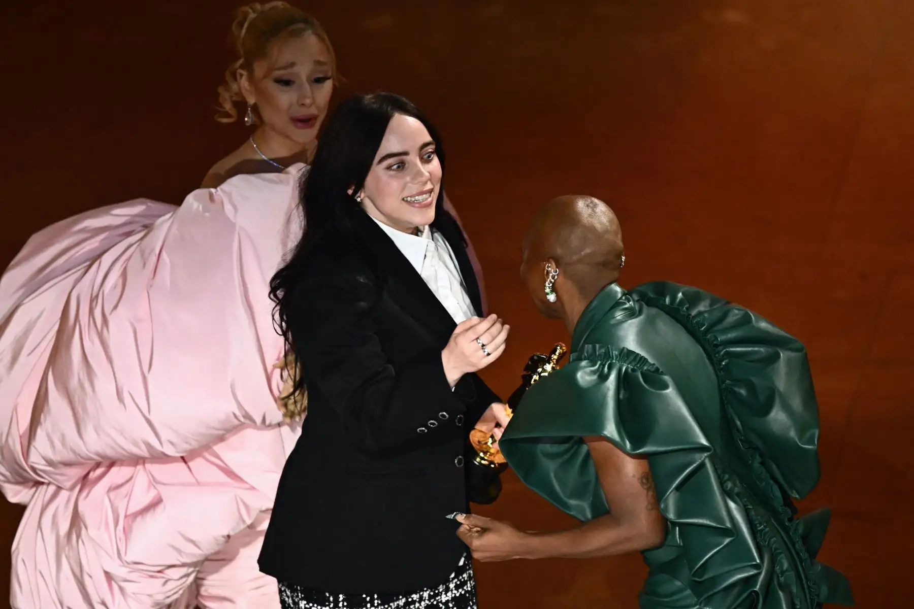 La actriz británica Cynthia Erivo (derecha) y la cantautora estadounidense Ariana Grande (i) entregan el premio a la mejor canción original por "What Was I Made For" de "Barbie" a la cantautora estadounidense Billie Eilish en el escenario durante la 96ª edición de los Premios Anuales de la Academia