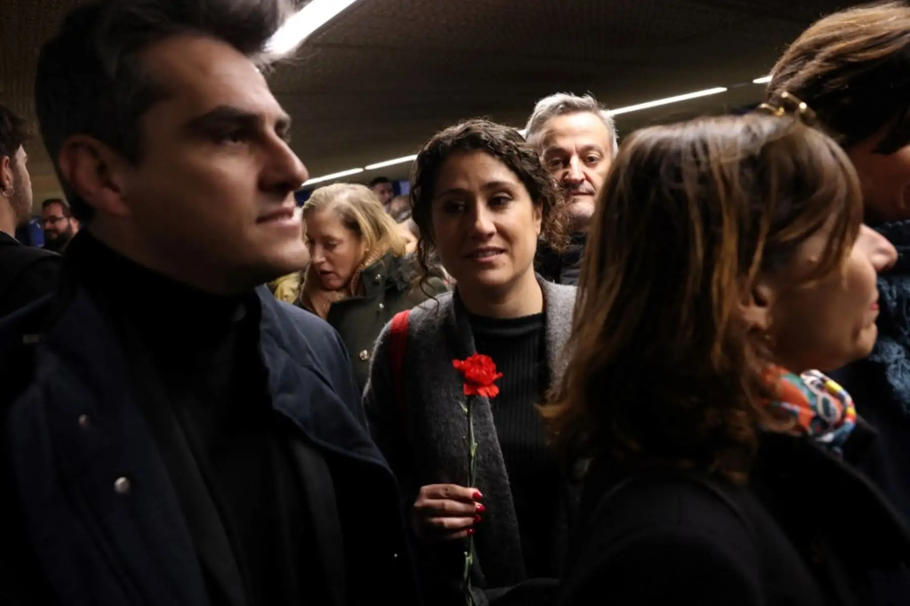 Familiares y amigos de las víctimas de los atentados del 11-M sostienen flores de clavel durante un homenaje en el espacio conmemorativo de la estación de Atocha en Madrid. Foto: AFP
