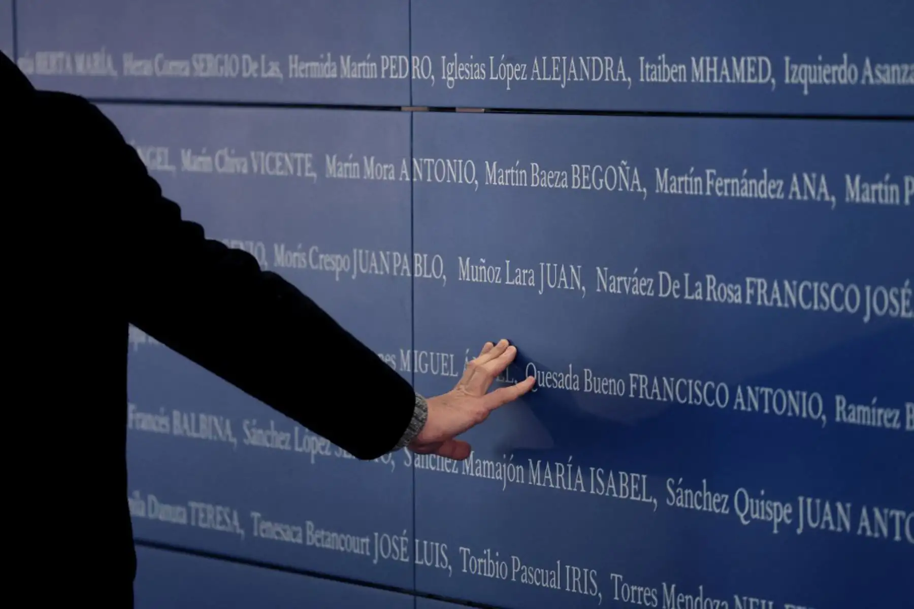 Un hombre toca un panel con los nombres de las víctimas de los atentados del 11-M, que mataron a 192 personas el 11 de marzo de 2004. Foto: AFP
