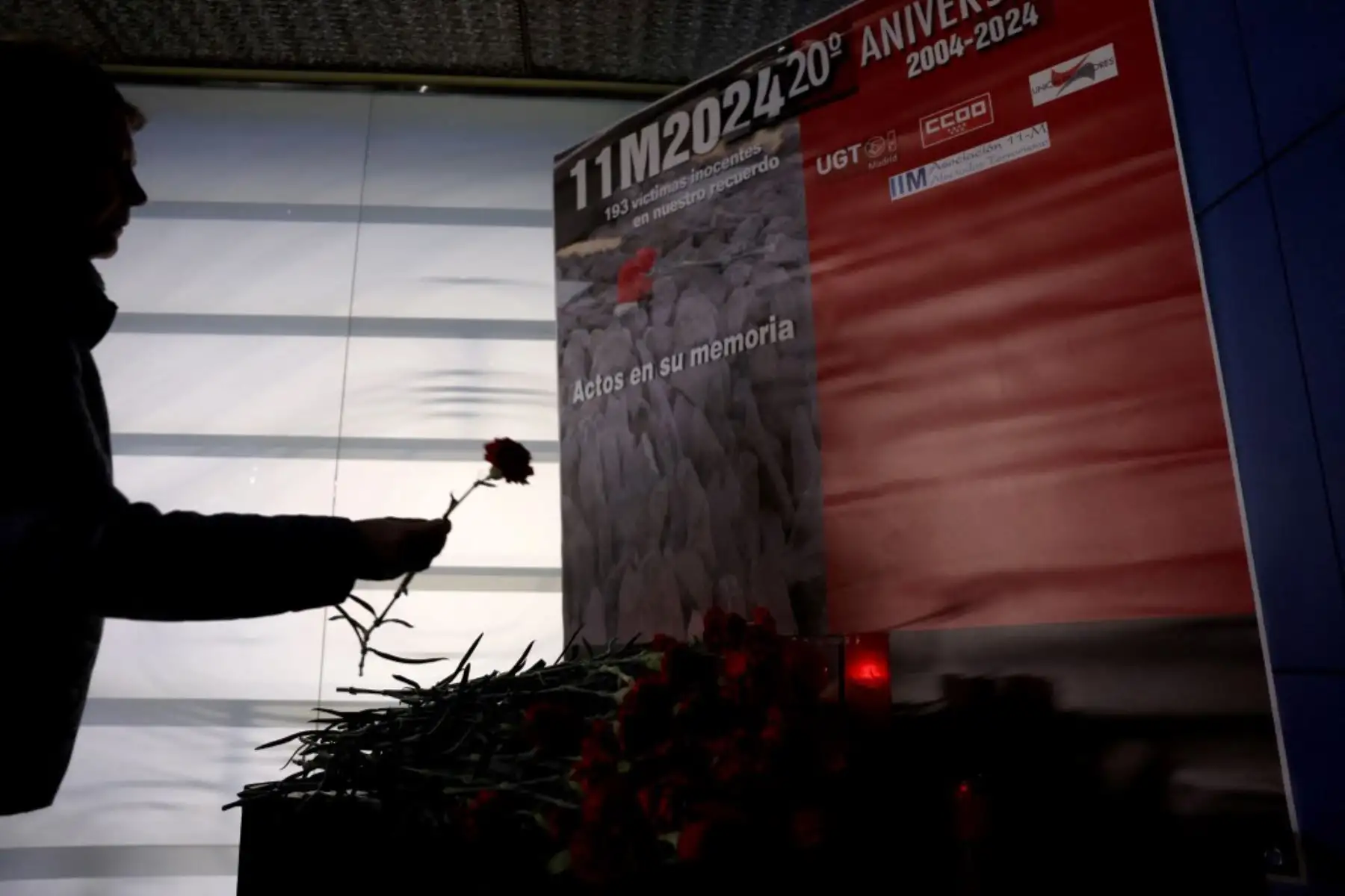 Familiares y amigos de las víctimas de los atentados del 11-M depositan flores de clavel durante un homenaje en el espacio conmemorativo de la estación de Atocha en Madrid el 11 de marzo de 2024. Foto: AFP
