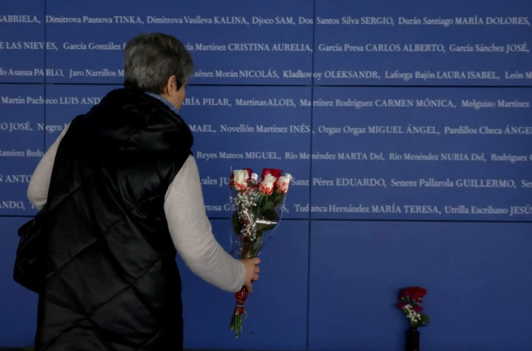 Un hombre toca un panel con los nombres de las víctimas de los atentados del 11-M, que mataron a 192 personas el 11 de marzo de 2004. Foto: AFP