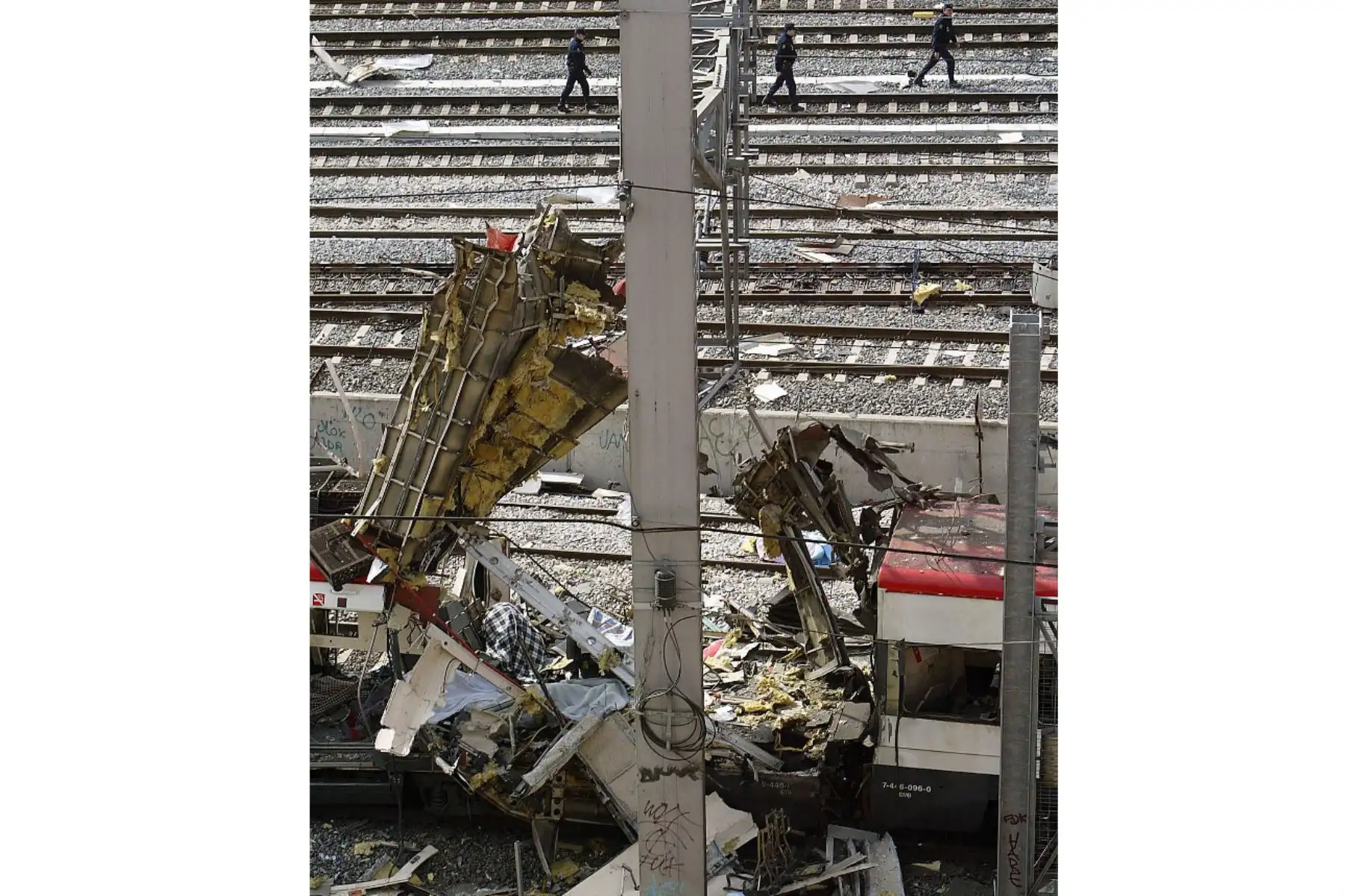 Policías caminan junto al tren que resultó dañado por la explosión de una bomba en la estación de tren de Atocha en Madrid el 11 de marzo de 2004. Foto: AFP