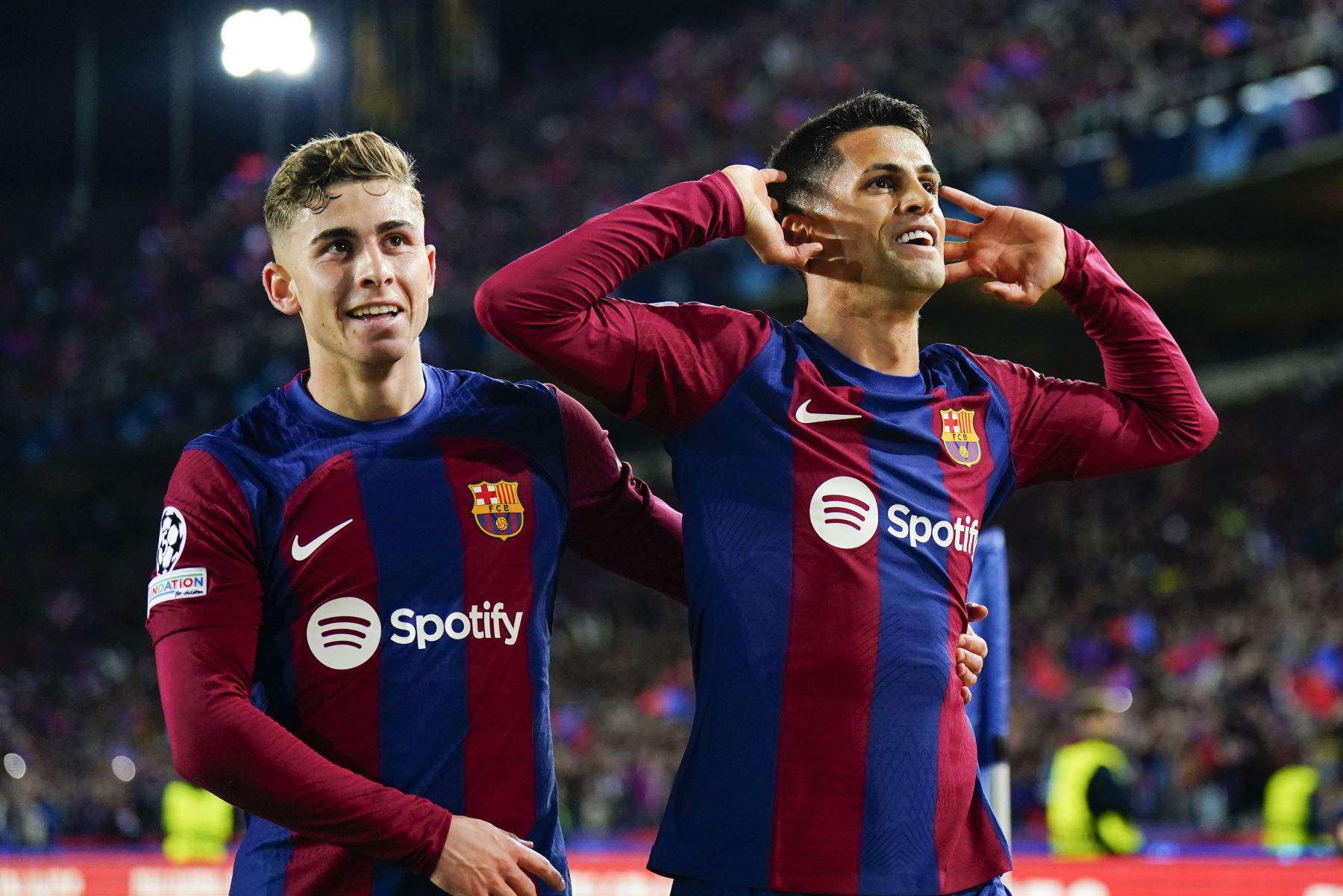 El defensa portugués del FC Barcelona, Joao Cancelo, celebra con Fermín López el segundo gol conseguido ante el Nápoles, durante el partido de vuelta de los octavos de final de la Liga de Campeones en el Estadio Olímpico Lluís Companys. Foto: EFE