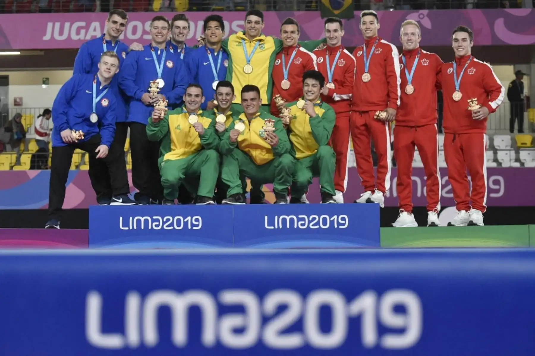 Los equipos de Estados Unidos,  Brasil y Canadá posan en el podio con sus medallas de plata, oro y bronce respectivamente, luego de su clasificación por equipos masculinos y final por equipos en los Juegos Panamericanos Lima 2019, el 28 de julio de 2019. Foto: AFP