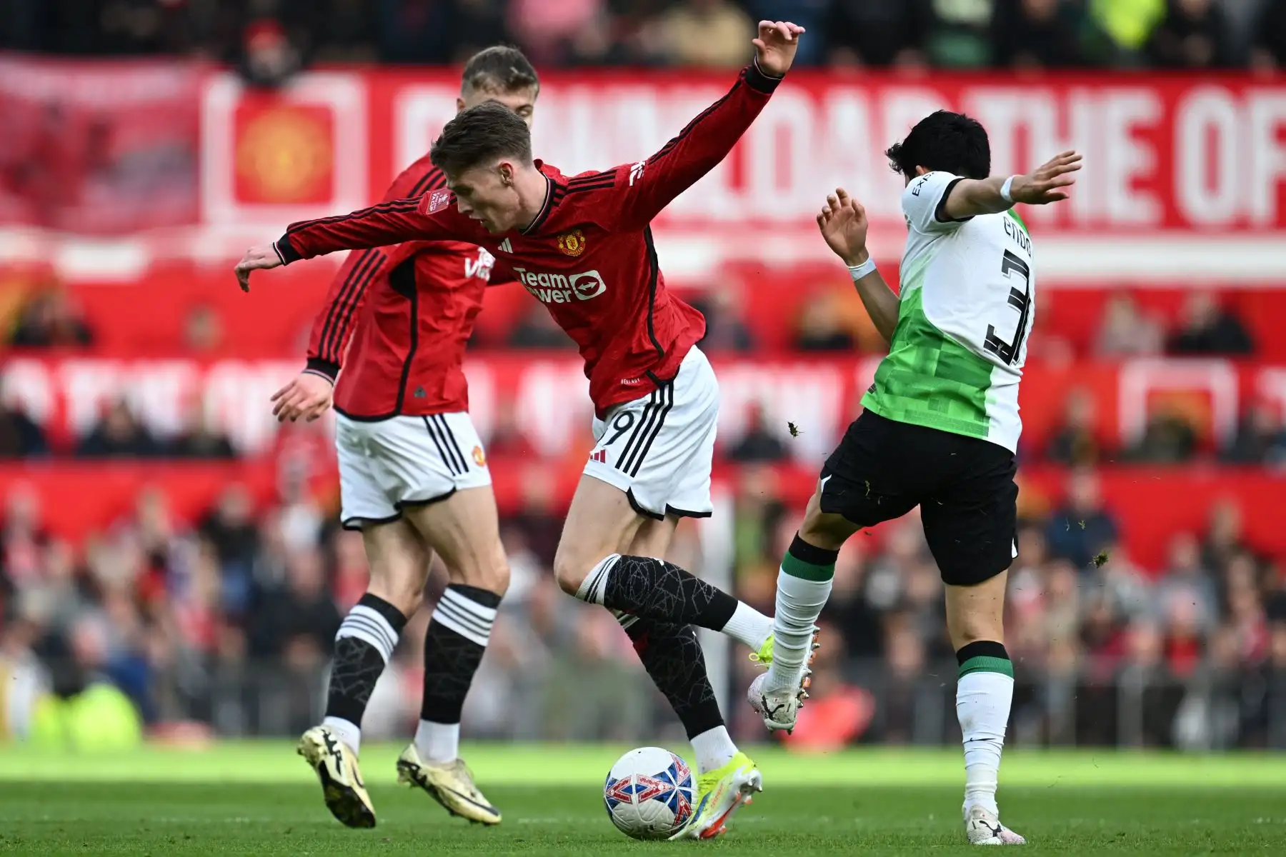 El centrocampista japonés del Liverpool Wataru Endo compite con el centrocampista escocés del Manchester United Scott McTominay  y el delantero danés del Manchester United Rasmus Hojlund durante el partido de fútbol de los cuartos de final de la Copa FA inglesa entre el Manchester United y el Liverpool. Foto: ANDINA/AFP