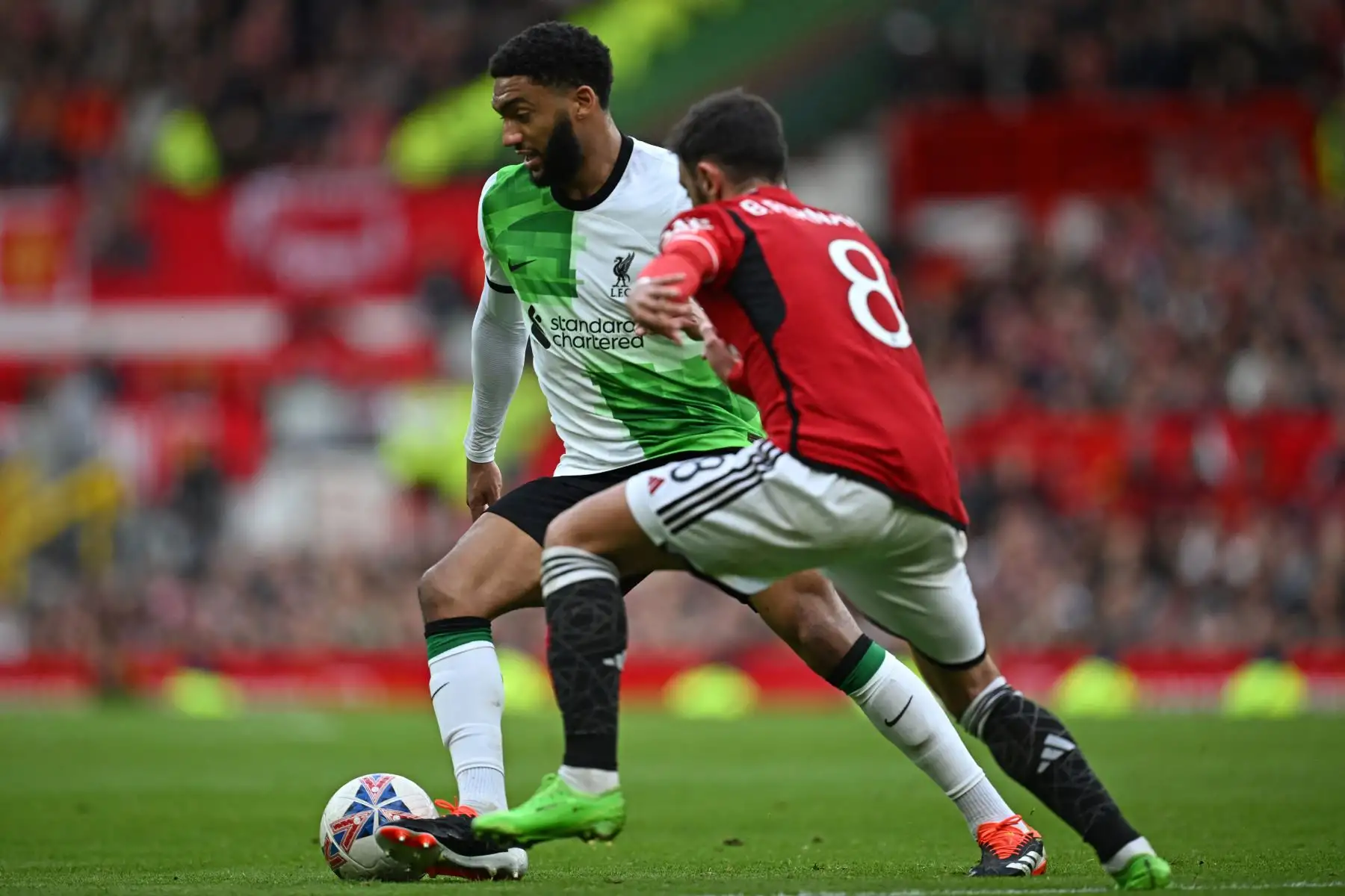 El defensor inglés del Liverpool Joe Gomez compite con el centrocampista portugués del Manchester United Bruno Fernandes durante el partido de fútbol de los cuartos de final de la Copa FA inglesa entre el Manchester United y el Liverpool.  Foto: ANDINA/AFP