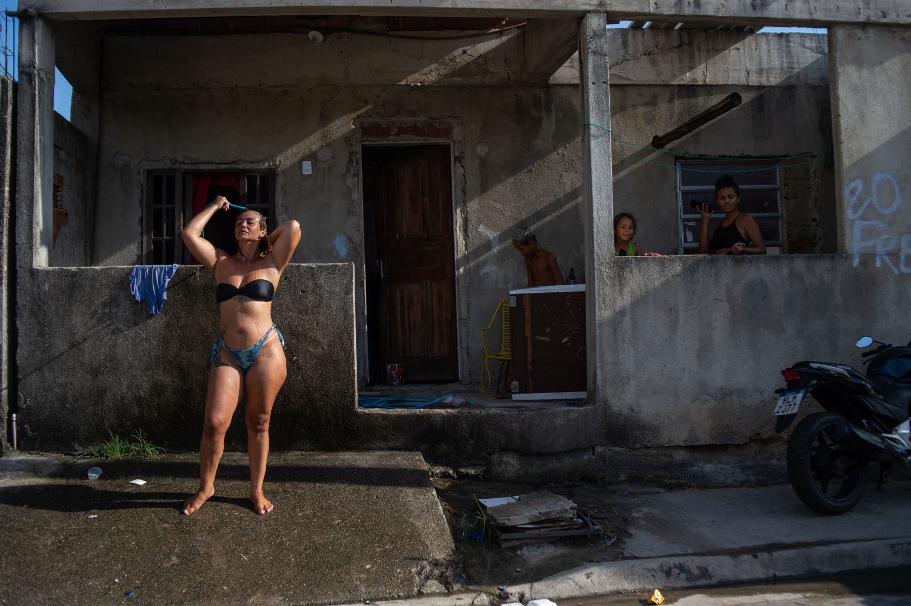 Una mujer se refresca con una manguera en la calle durante una ola de calor, en el barrio de Guaratiba en Río de Janeiro, Brasil, el 17 de enero de 2024. Según el Ayuntamiento de Río de Janeiro, la zona oeste de Guaratiba alcanzó una sensación de calor de 59,5°C. Foto: AFP