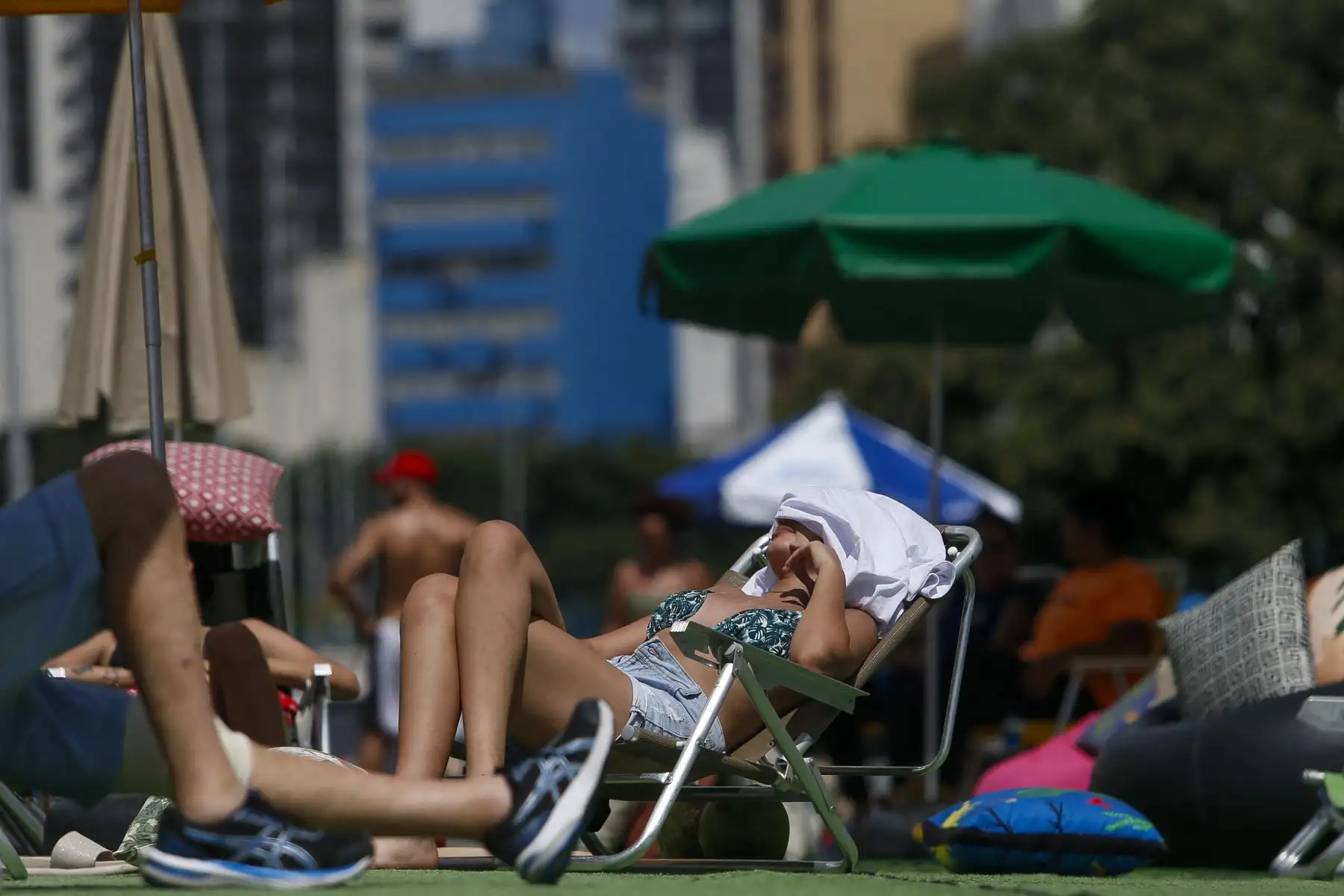Una mujer toma el sol en medio de una ola de calor en la ciudad de Sao Paulo, Brasil, el 17 de marzo de 2024. Una nueva ola de calor está azotando Brasil, con temperaturas récord que llevaron a los residentes de Río de Janeiro y Sao Paulo el domingo a acudir a playas y parques. En el oeste de Río, la sensación térmica alcanzó los 60,1 grados centígrados el sábado. Foto: AFP