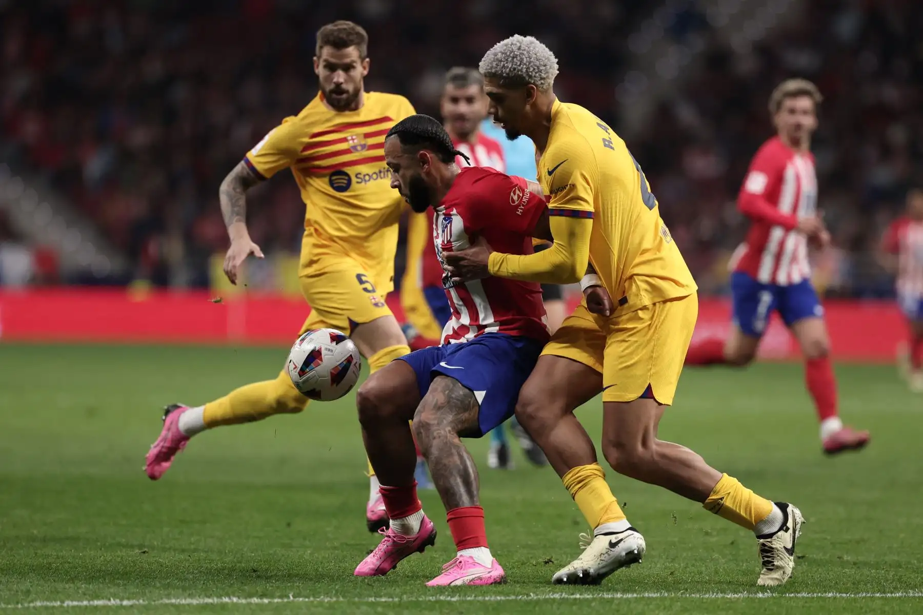El delantero holandés del Atlético de Madrid #09 Memphis Depay compite por el balón con el defensa uruguayo del Barcelona #04 Ronald Araujo (R) durante el partido de fútbol de la liga española entre el Club Atlético de Madrid y el FC Barcelona en el estadio Metropolitano de Madrid el 17 de marzo de 2024. Foto: AFP