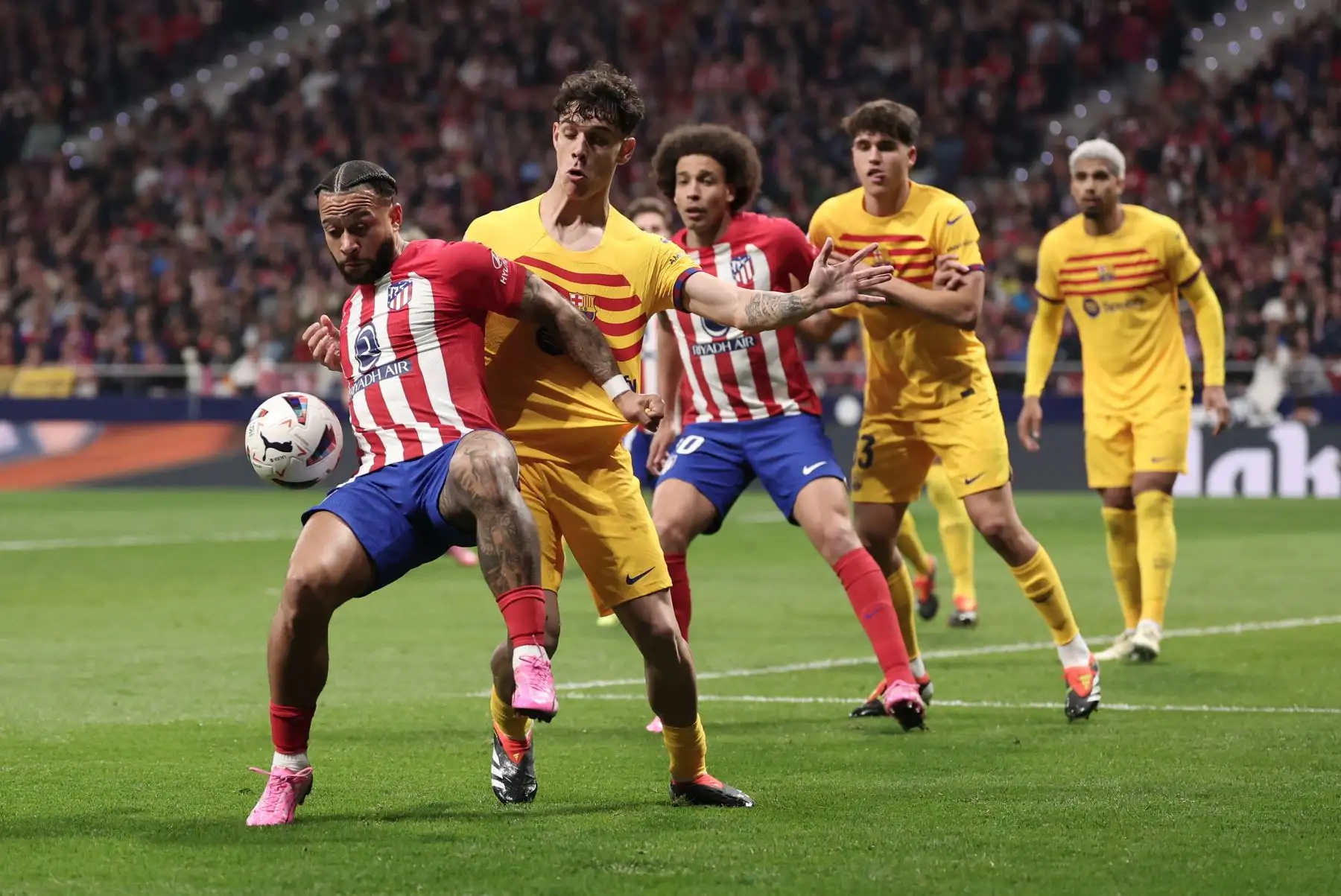 El defensor español del Barcelona #39 Hector Fort compite por el balón con el delantero holandés del Atlético de Madrid #09 Memphis Depay (L) durante el partido de fútbol de la liga española entre el Club Atlético de Madrid y el FC Barcelona en el estadio Metropolitano de Madrid el 17 de marzo de 2024. Foto: AFP