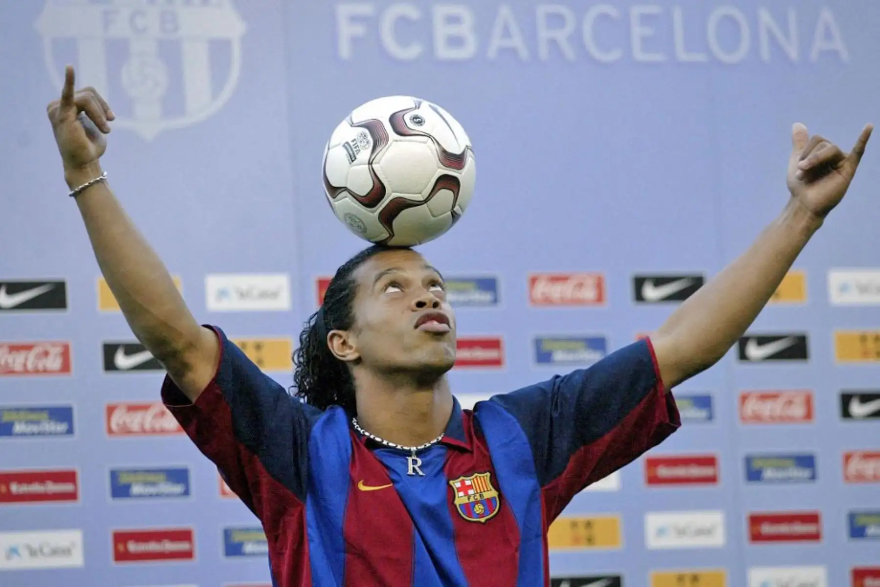 La nueva estrella del fútbol brasileño del Barcelona, ​​Ronaldinho, balancea el balón sobre su cabeza durante su presentación oficial en el estadio del Camp Nou de Barcelona, ​​el 21 de julio de 2003. Foto: AFP