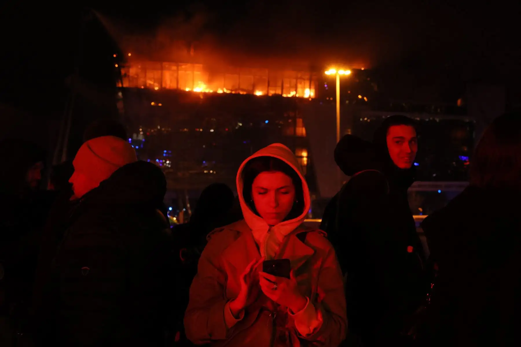Personas afuera de la sala de conciertos Crocus City Hall en llamas luego del incidente del tiroteo en Krasnogorsk, en las afueras de Moscú, en Rusia, el 22 de marzo de 2024. Foto: AFP