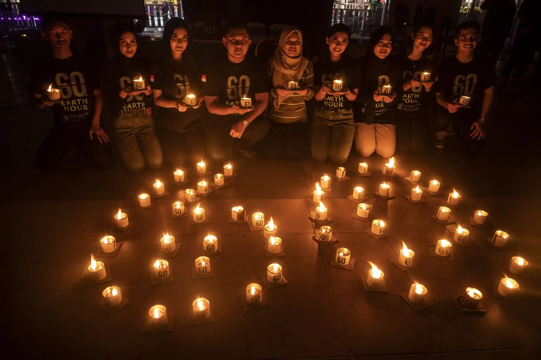 Activistas indonesios encienden velas para formar semiótica de 60 durante la campaña medioambiental La Hora del Planeta en Surabaya. Foto: AFP