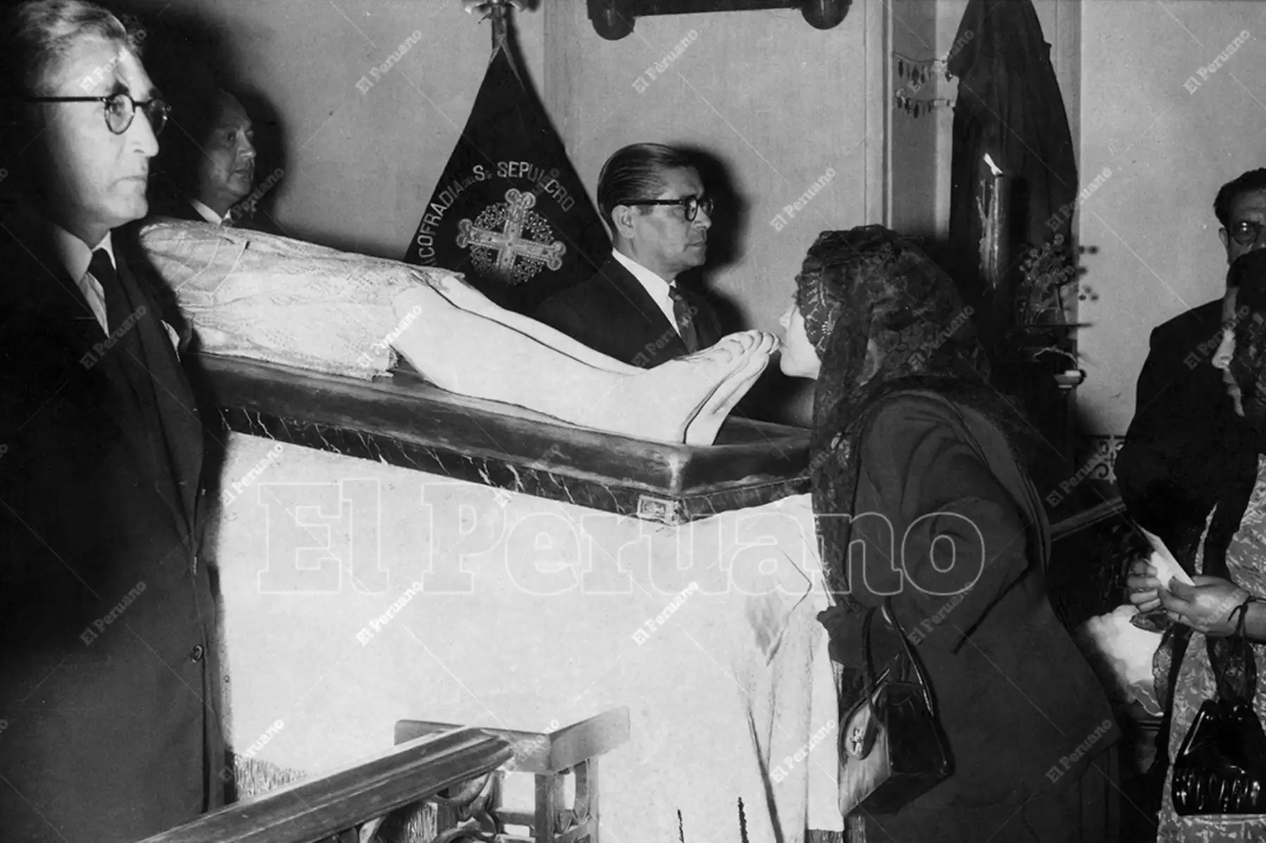 Lima - 29 marzo 1956 / Con guardia de honor formada por cabelleros de la Hermandad de Veracruz, estuvo expuesto a la veneración pública una imagen del Cristo yacente en el Templo de Jesús María. Una dama vestida de negro y con mantilla besa de la sagrada imagen. Foto: Archivo Histórico de El Peruano