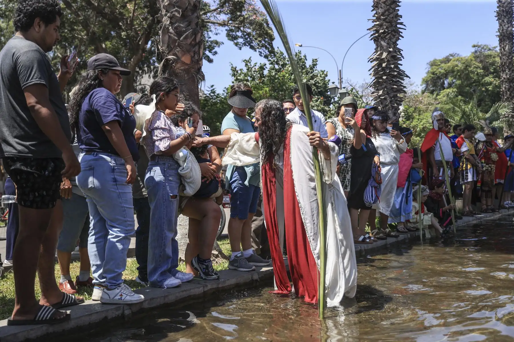 Mario Valencia, artísticamente conocido como el ‘Cristo Cholo’, junto a su grupo teatral, realizaron la representación simbólica del bautizo de Jesucristo. La escenificación se realizó en el Paseo de Aguas ubicado en el Rímac. Foto: ANDINA/Jhonel Rodríguez Robles