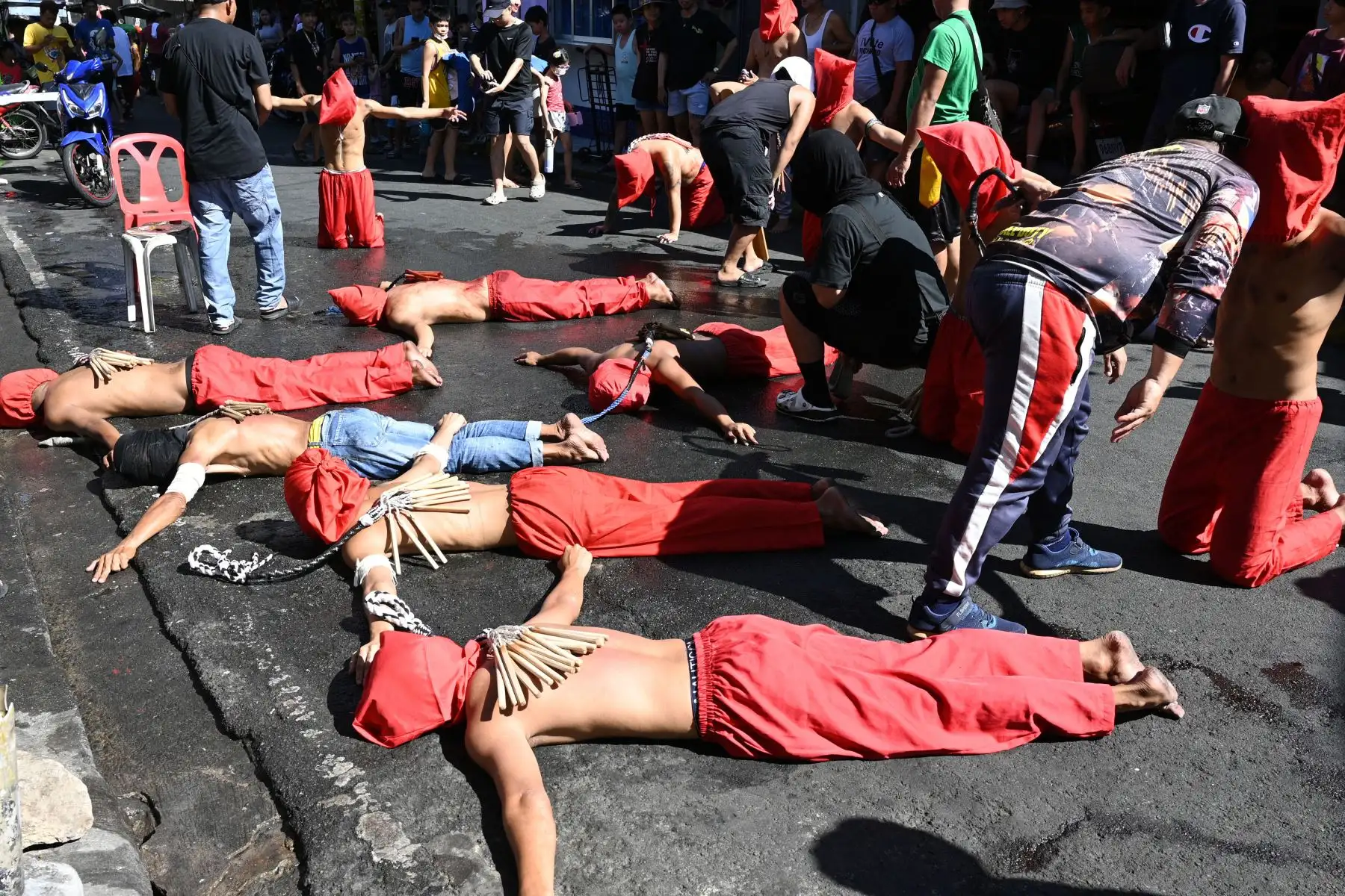 Penitentes postrados frente a una capilla mientras se flagelan como parte de la observancia de la Cuaresma. Foto: ANDINA/AFP