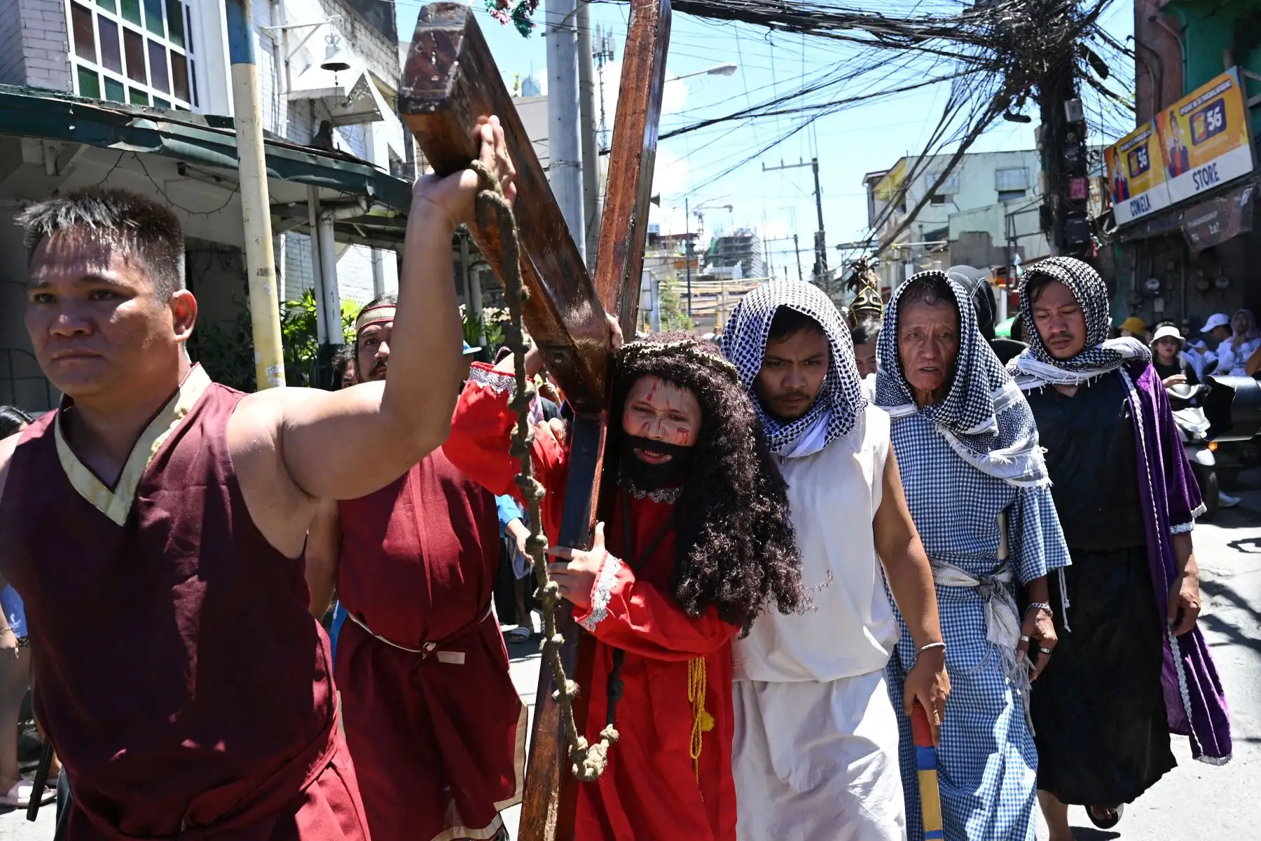 Un actor que interpreta el papel de Jesús lleva una cruz de madera durante la recreación del sufrimiento y la crucifixión de Jesús en una obra de teatro callejera como parte de la observancia de la Cuaresma durante la Semana Santa.
Foto: ANDINA/AFP