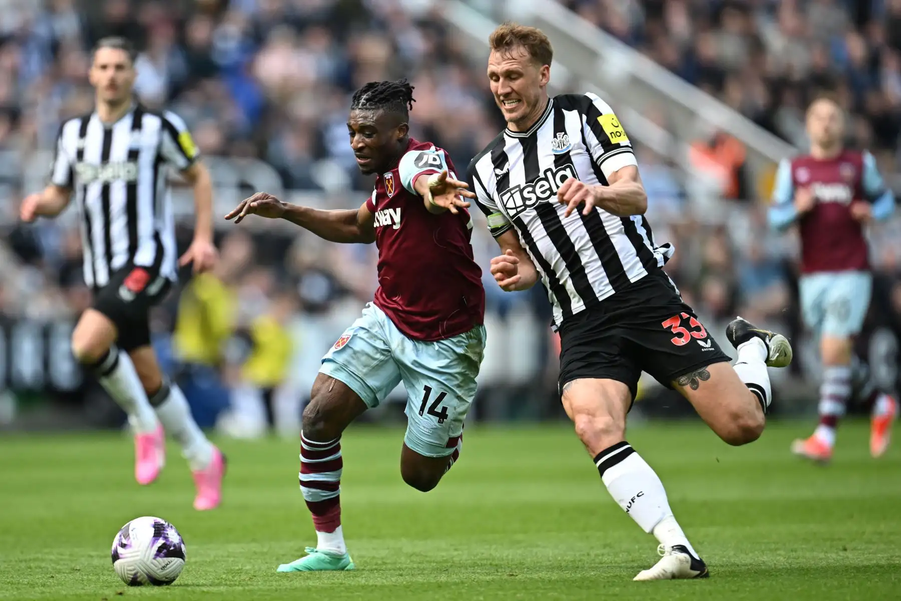 El centrocampista ghanés del West Ham United  Mohammed Kudus  compite con el defensor inglés del Newcastle United Dan Burn durante el partido de fútbol de la Premier League inglesa entre Newcastle United y West Ham United en St James