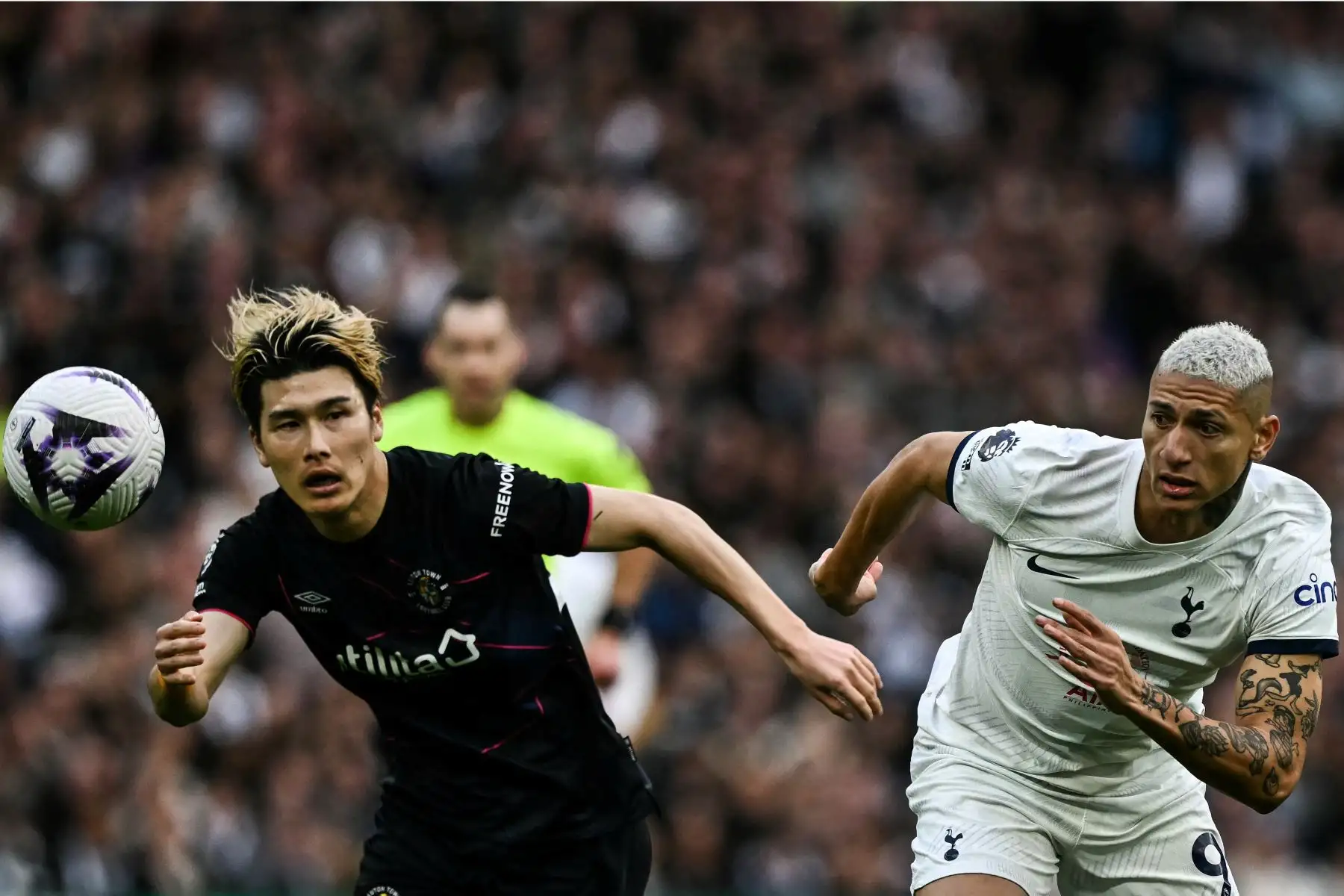 El defensor japonés de Luton Town Daiki Hashioka  y el delantero brasileño de Tottenham Hotspur  Richarlison  luchan por el balón durante el partido de fútbol de la Premier League inglesa entre Tottenham Hotspur y Luton Town en el estadio Tottenham Hotspur de Londres. Foto: ANDINA/AFP