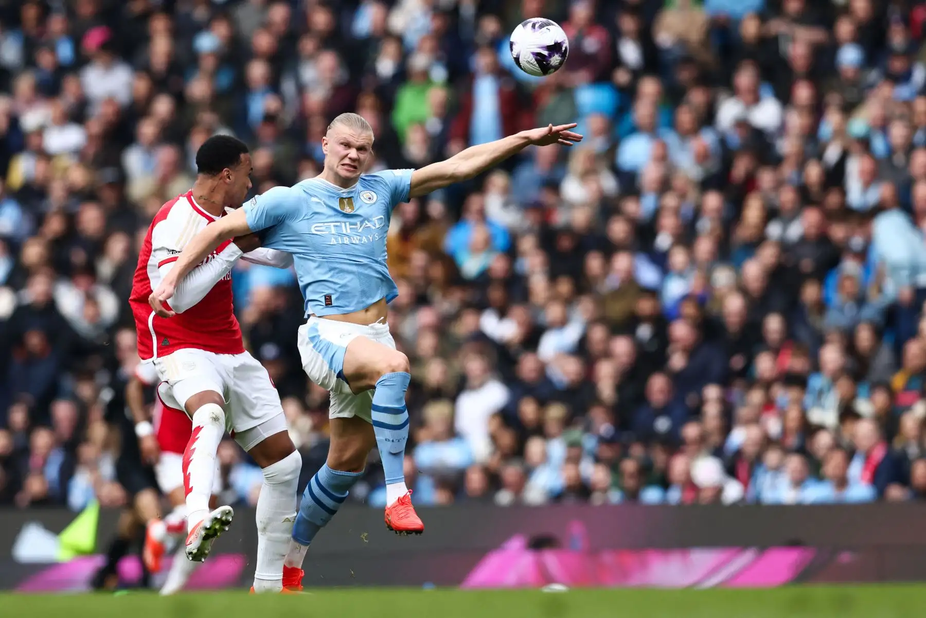 El defensor brasileño del Arsenal Gabriel Magalhaes lucha por el balón con el delantero noruego del Manchester City Erling Haaland durante el partido de fútbol de la Premier League inglesa entre Manchester City y Arsenal en el estadio Etihad de Manchester, noroeste de Inglaterra. Foto: ANDINA/AFP