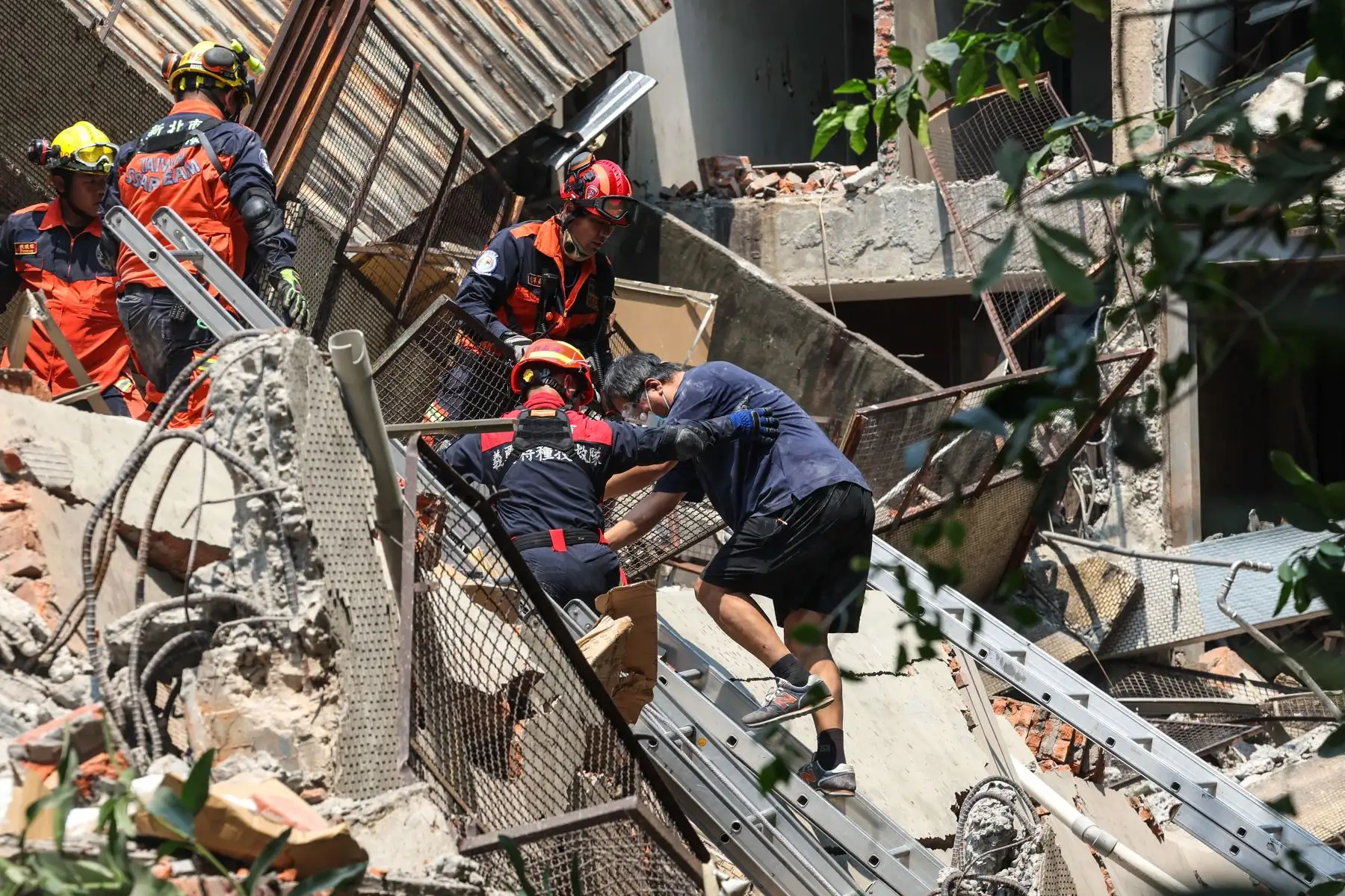 Esta foto tomada por la Agencia Central de Noticias de Taiwán (CNA)  muestra a los trabajadores de emergencia ayudando a un sobreviviente después de que fue rescatado de un edificio dañado en la ciudad de Nuevo Taipei, después de que un gran terremoto azotara el este de Taiwán. 
Foto: AFP
